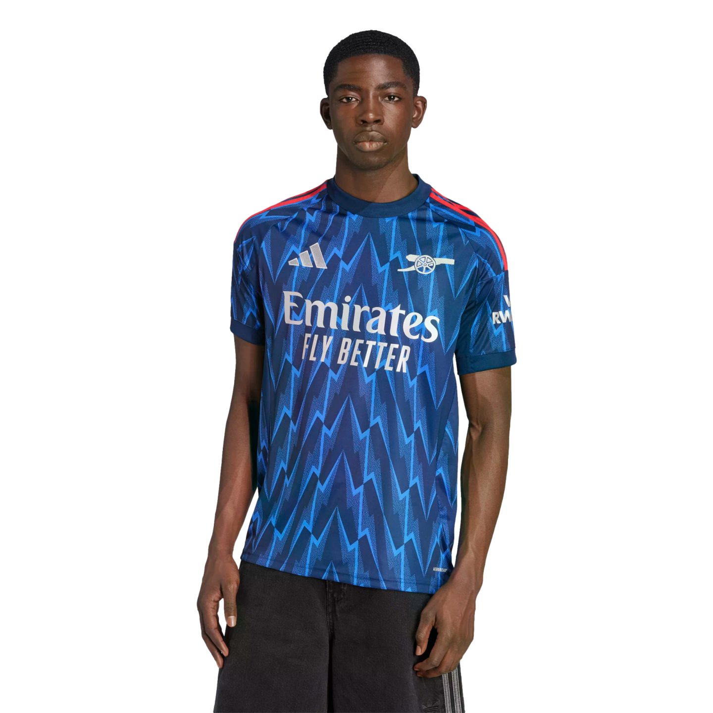 Man modeling a blue Arsenal football jersey with a zigzag pattern and white Emirates logo on a black background.