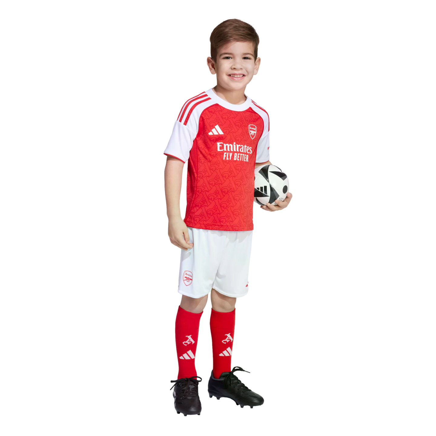 A smiling boy in an Arsenal football kit holds a soccer ball against a white background.