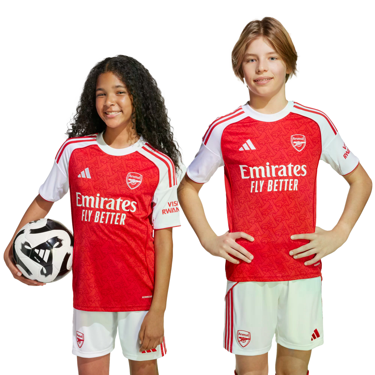 Two children in Arsenal FC home kits; a girl holds a football, and a boy stands with hands on hips. Both smile against a plain white background.
