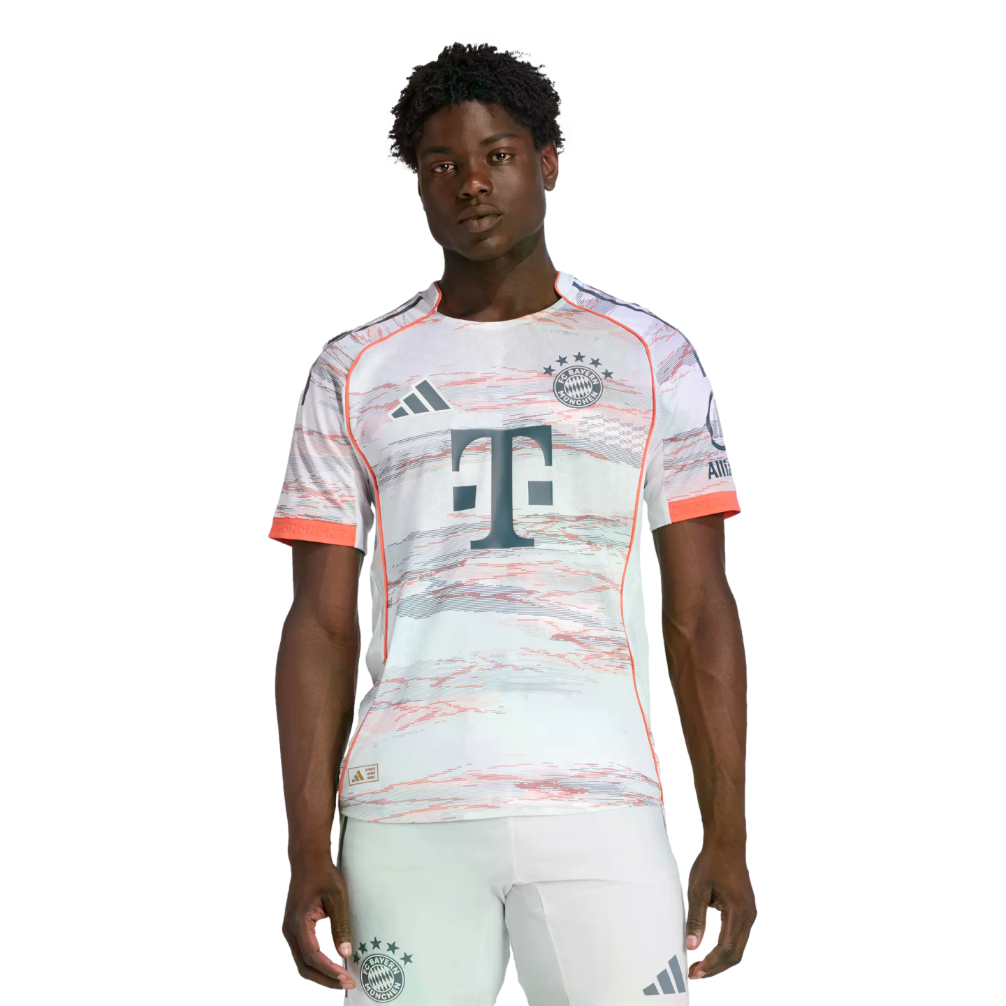 A man modeling an Adidas FC Bayern Munich soccer kit featuring a patterned white jersey and matching shorts against a plain white background.