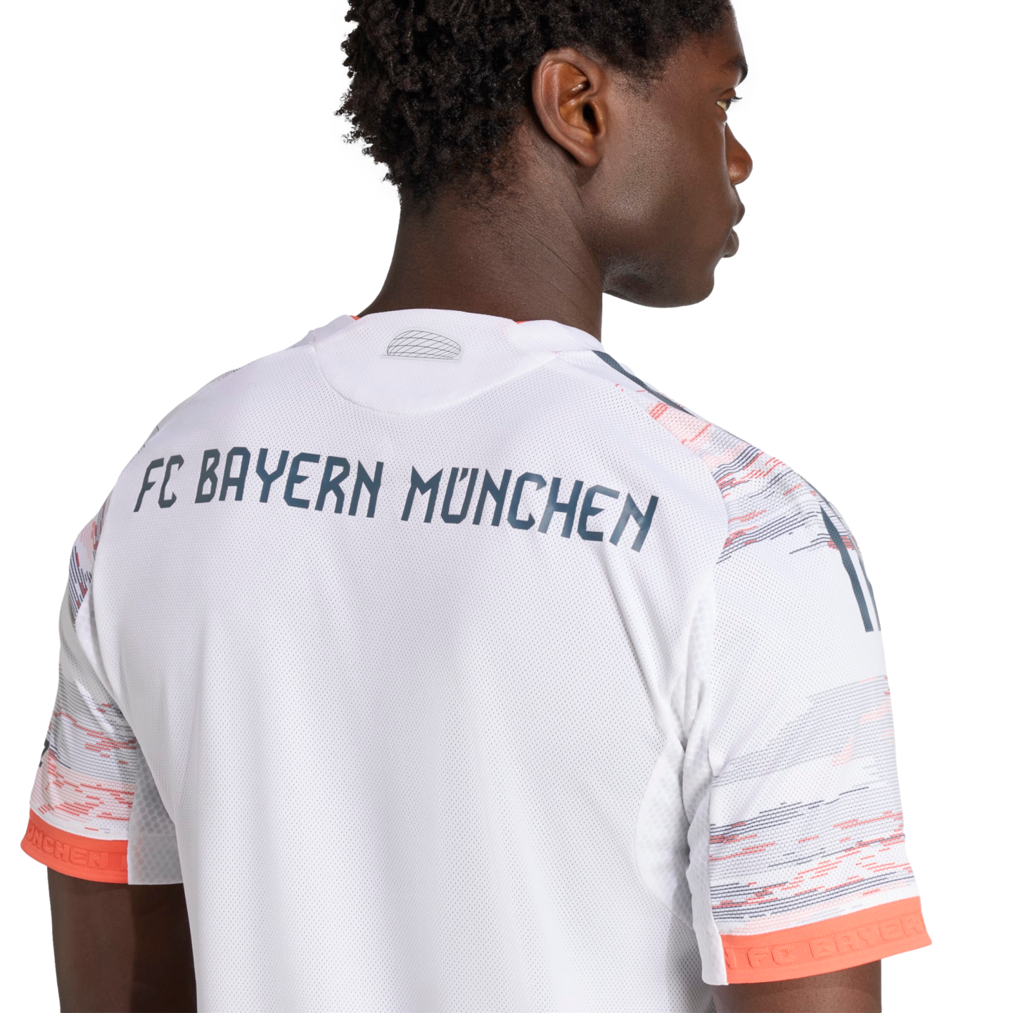 The back of a man wearing a white FC Bayern München soccer jersey with navy lettering and orange-patterned sleeves.