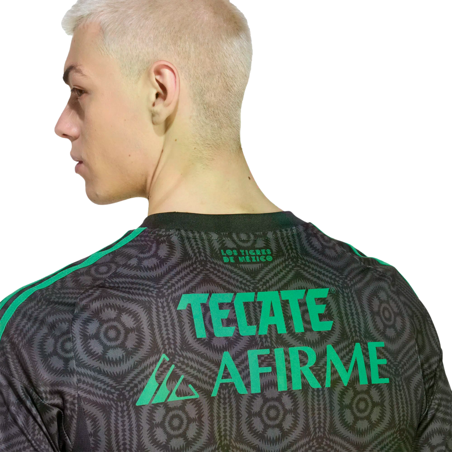 Side profile of a blonde man wearing a grey patterned jersey with green "TECATE" and "AFIRME" text on the back. Solid black background.