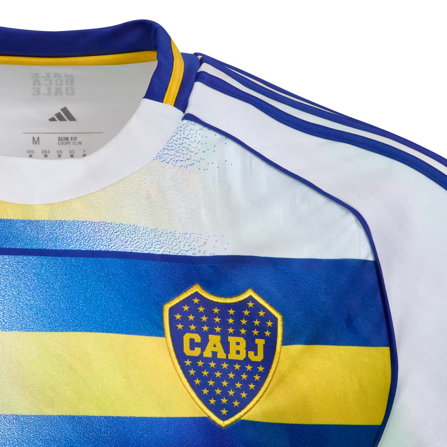 Close-up of a white, blue, and yellow Boca Juniors jersey featuring the CABJ crest on a blue band, three blue stripes on the shoulder, and internal Adidas branding.