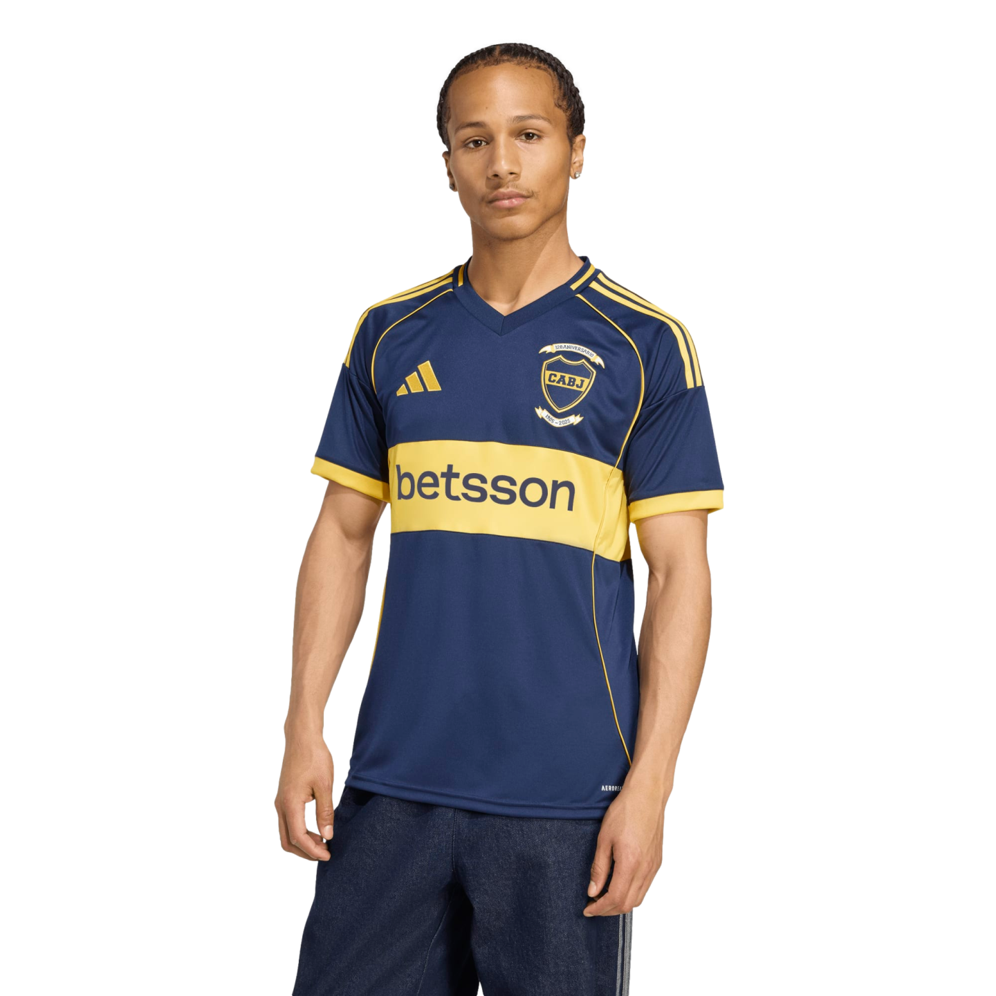 A man models a navy blue and yellow Adidas soccer jersey with a CABJ crest and "betsson" sponsor logo against a white background.