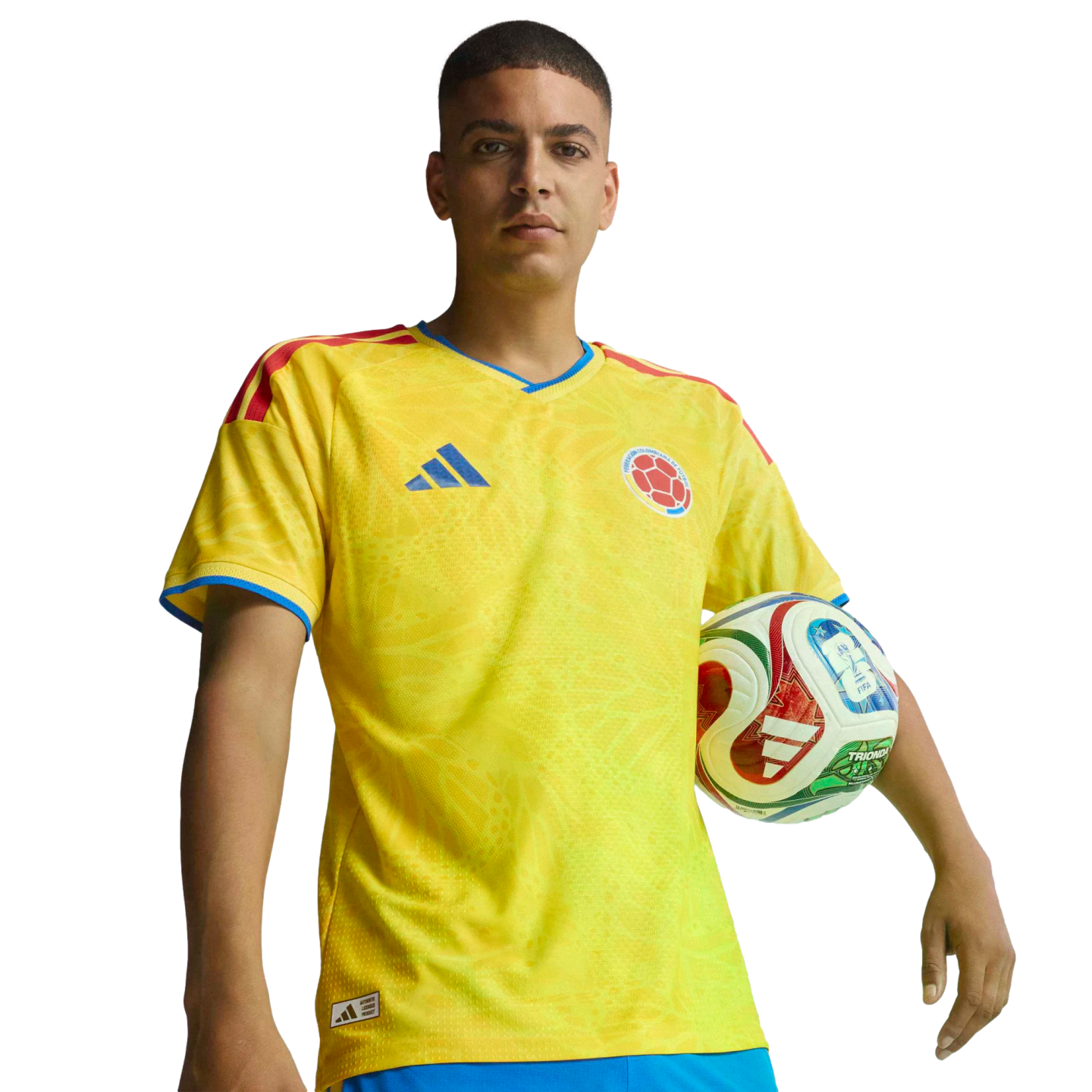 Man in a yellow Colombian national team soccer jersey, holding a soccer ball against a black background.