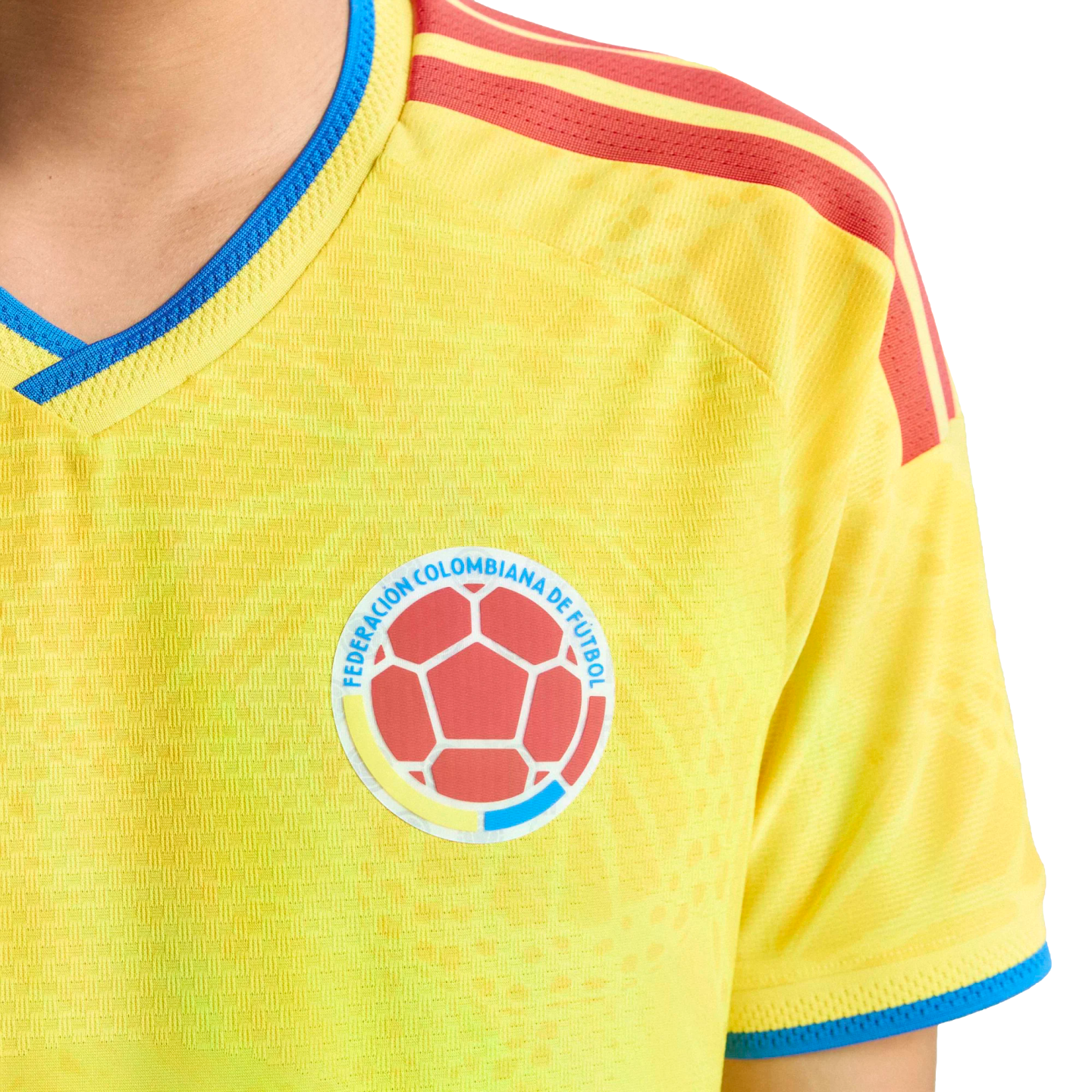 Yellow Colombian national soccer jersey with blue trim and red shoulder stripes, featuring the official federation crest on the chest.