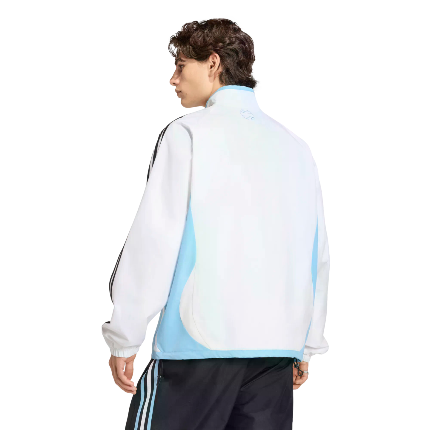 Rear view of a man in a white and light blue track jacket and black track pants with light blue stripes, set against a black background.