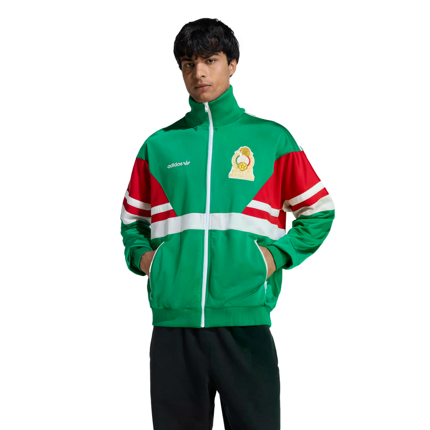 A man in a green, red, and white Adidas track jacket with the Mexico national team crest poses against a black background.