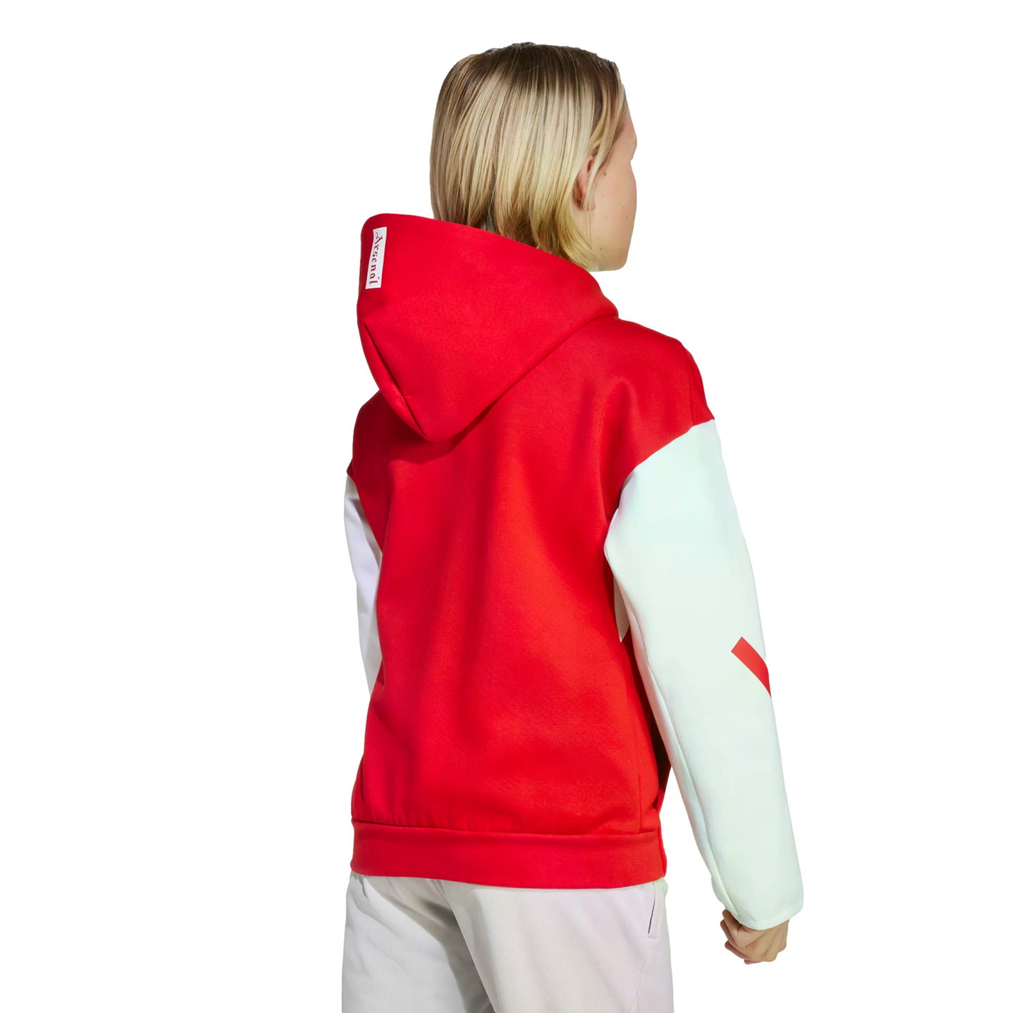 Rear view of a blonde person wearing a red hoodie with white sleeves and light-colored pants against a black background.