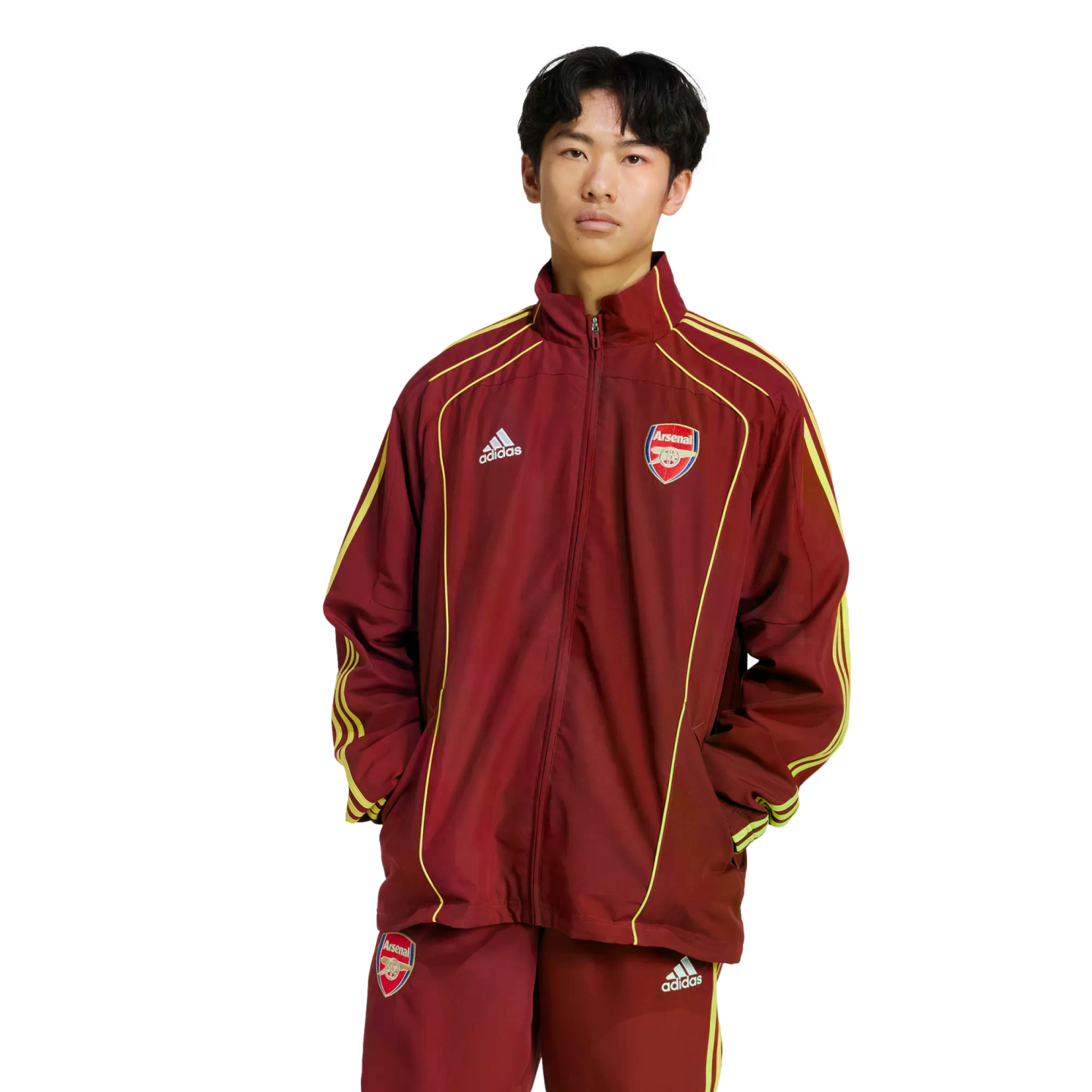 A person wearing a maroon and gold Adidas Arsenal football tracksuit, standing against a plain white background.