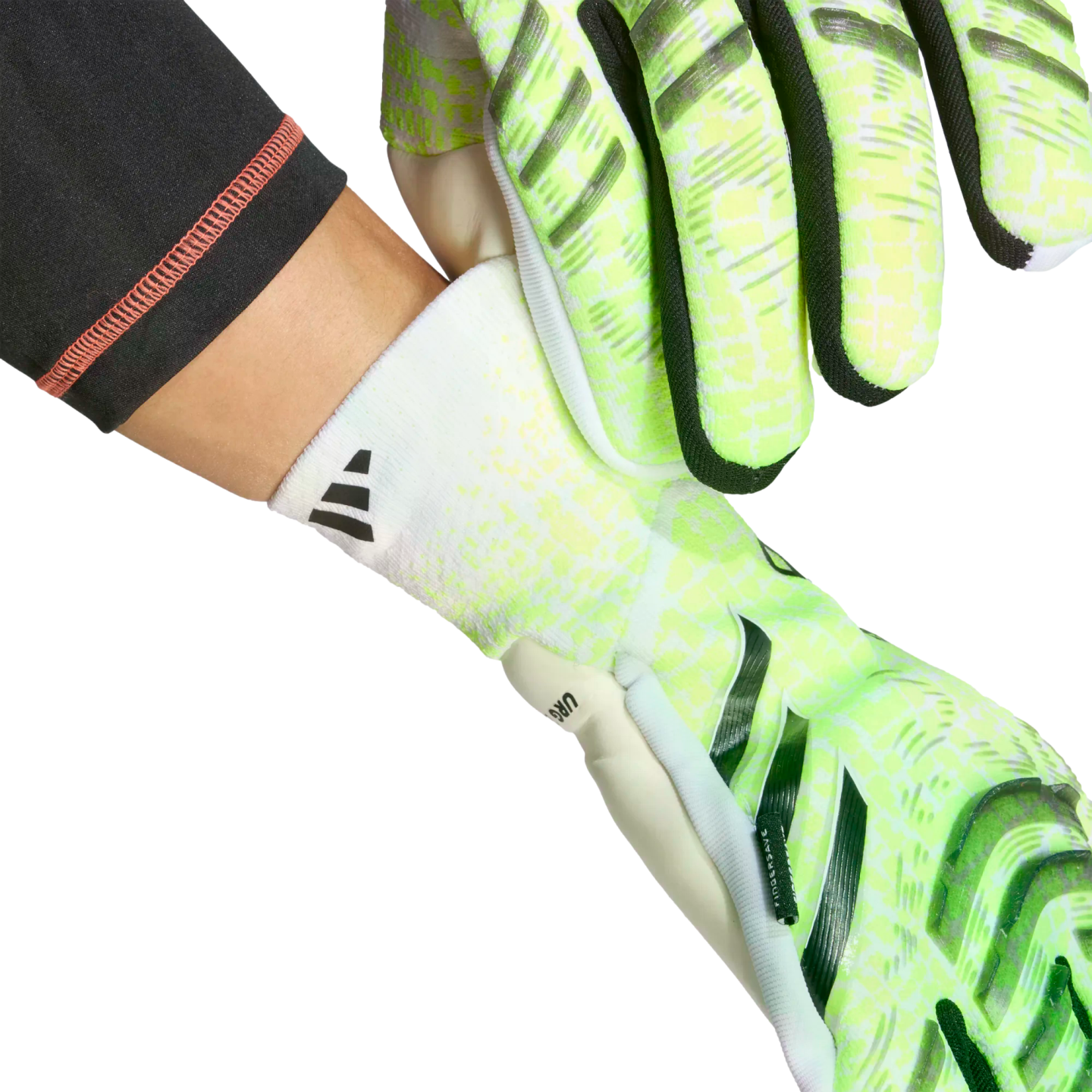 Hands putting on neon green and white Adidas goalkeeper gloves with white elasticated wrist cuffs.
