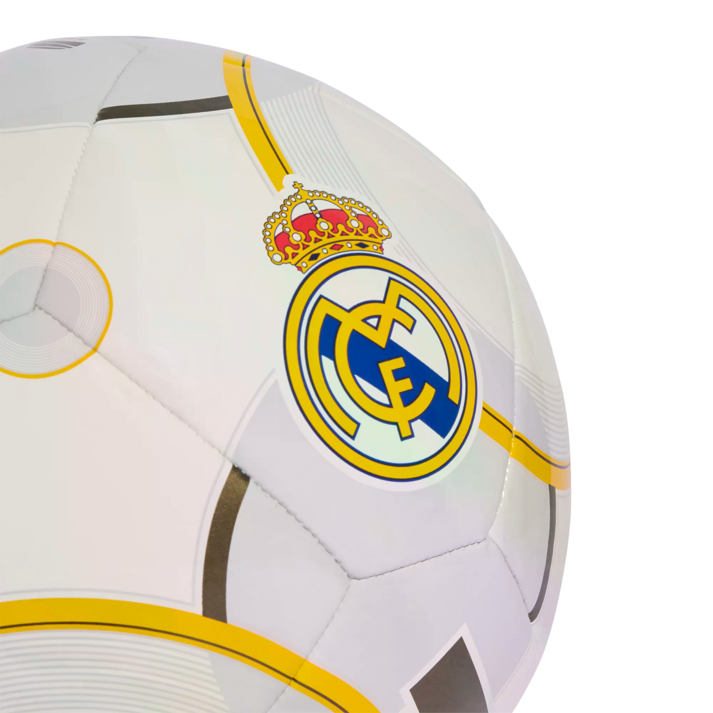 Close-up of a white soccer ball featuring the Real Madrid C.F. club crest with gold and grey accents.