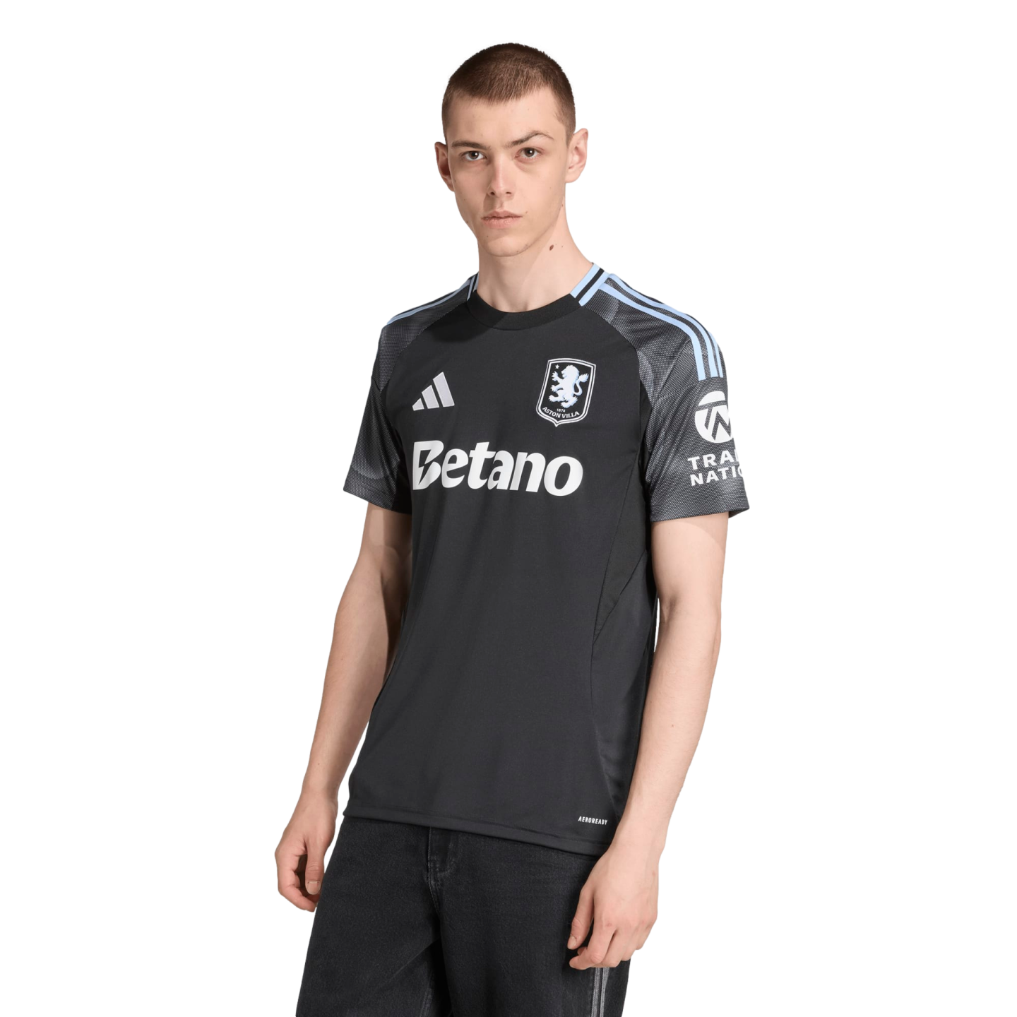 A man modeling a black and grey Adidas Aston Villa soccer jersey with light blue accents, featuring the Betano sponsor logo.