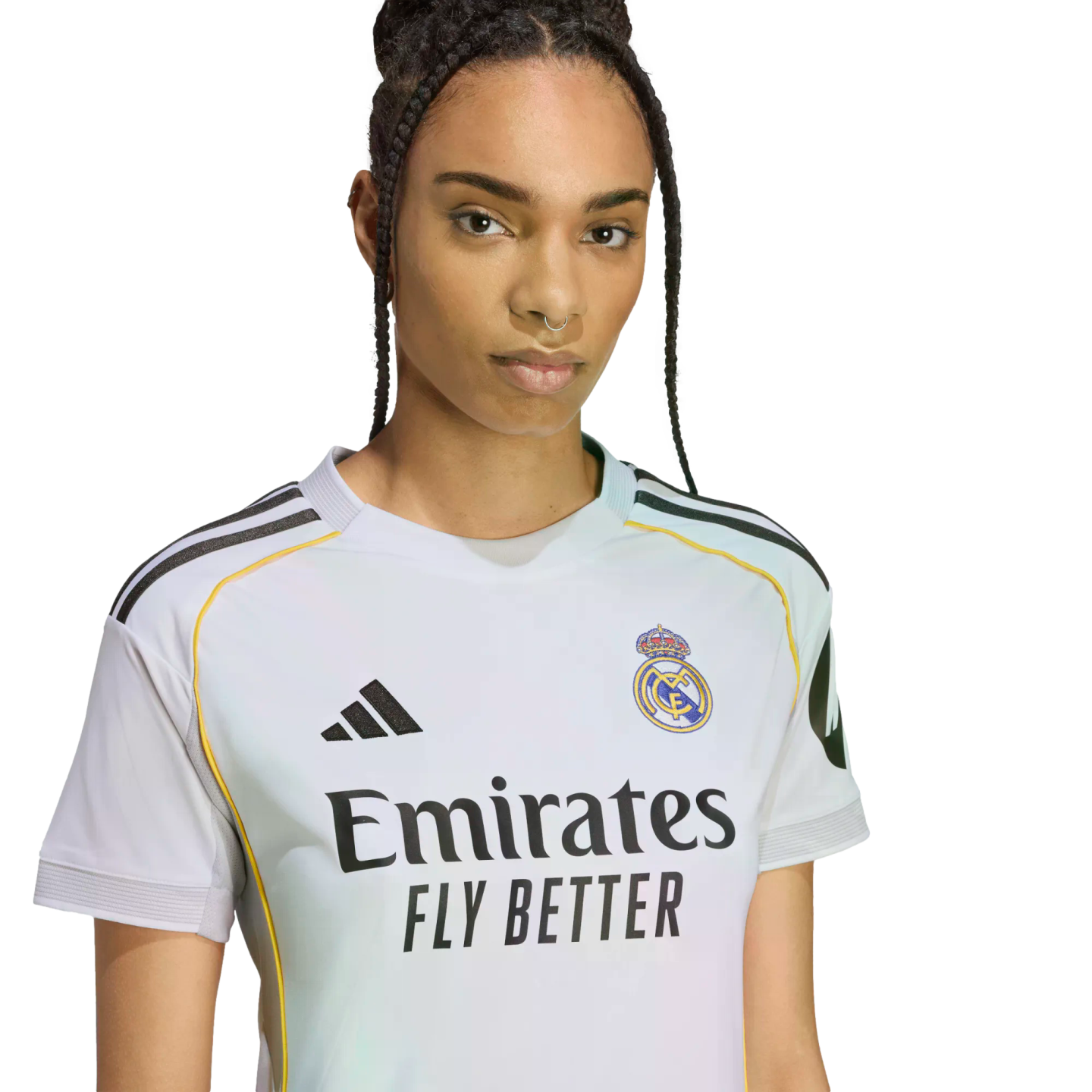 A person with braided hair wearing a white Real Madrid home soccer jersey featuring the team crest and the "Emirates FLY BETTER" sponsor logo.