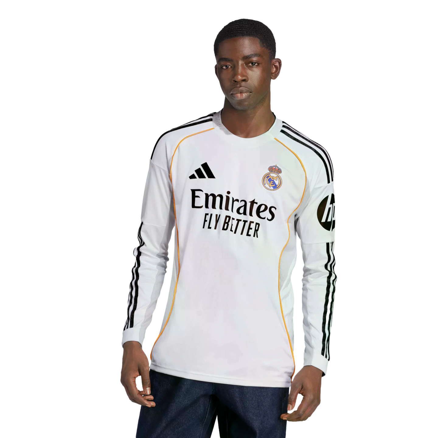 A young Black man models a white long-sleeved Real Madrid soccer jersey with black Adidas stripes and sponsor logos.