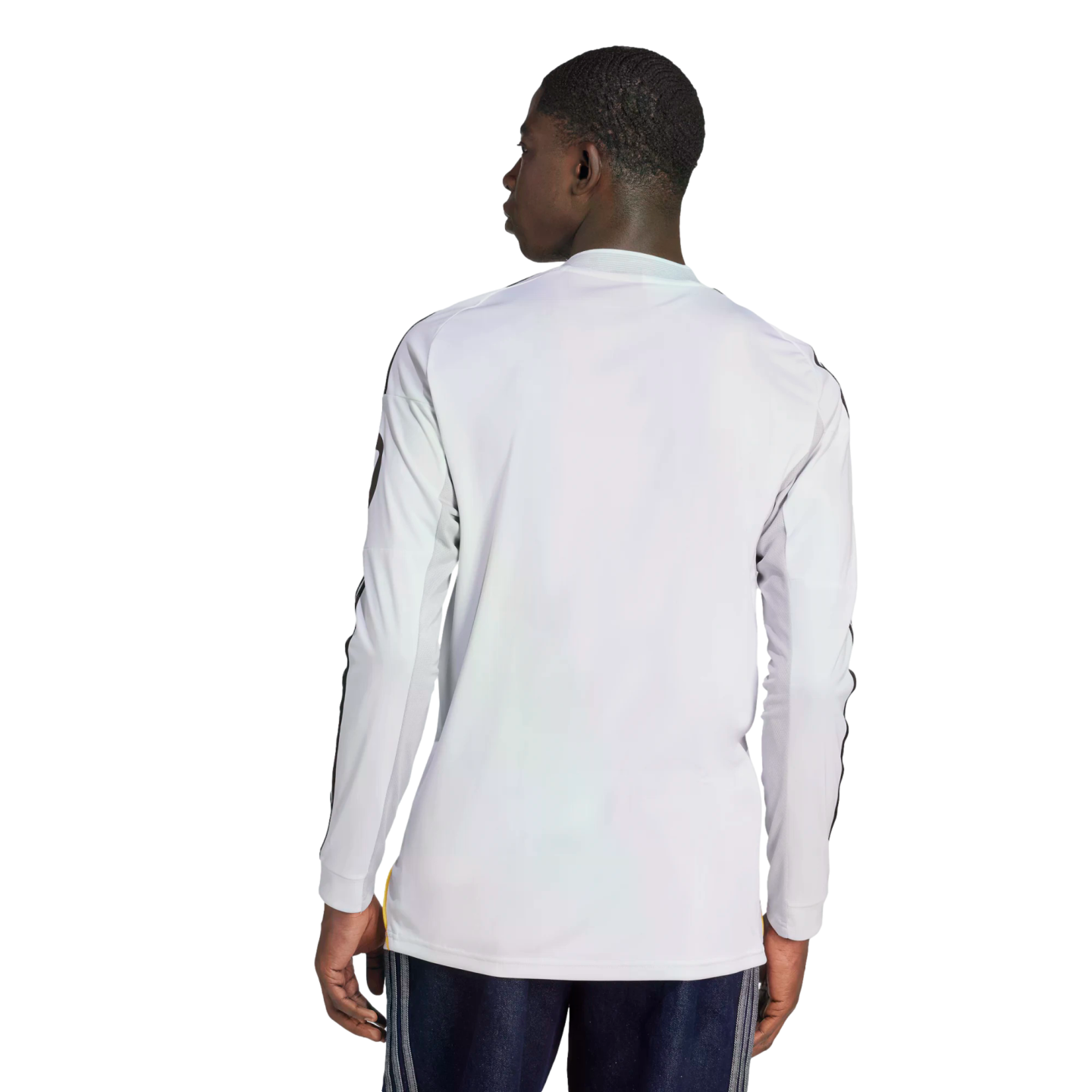 Rear view of a man wearing a white long-sleeved athletic shirt with black sleeve stripes and dark blue shorts.