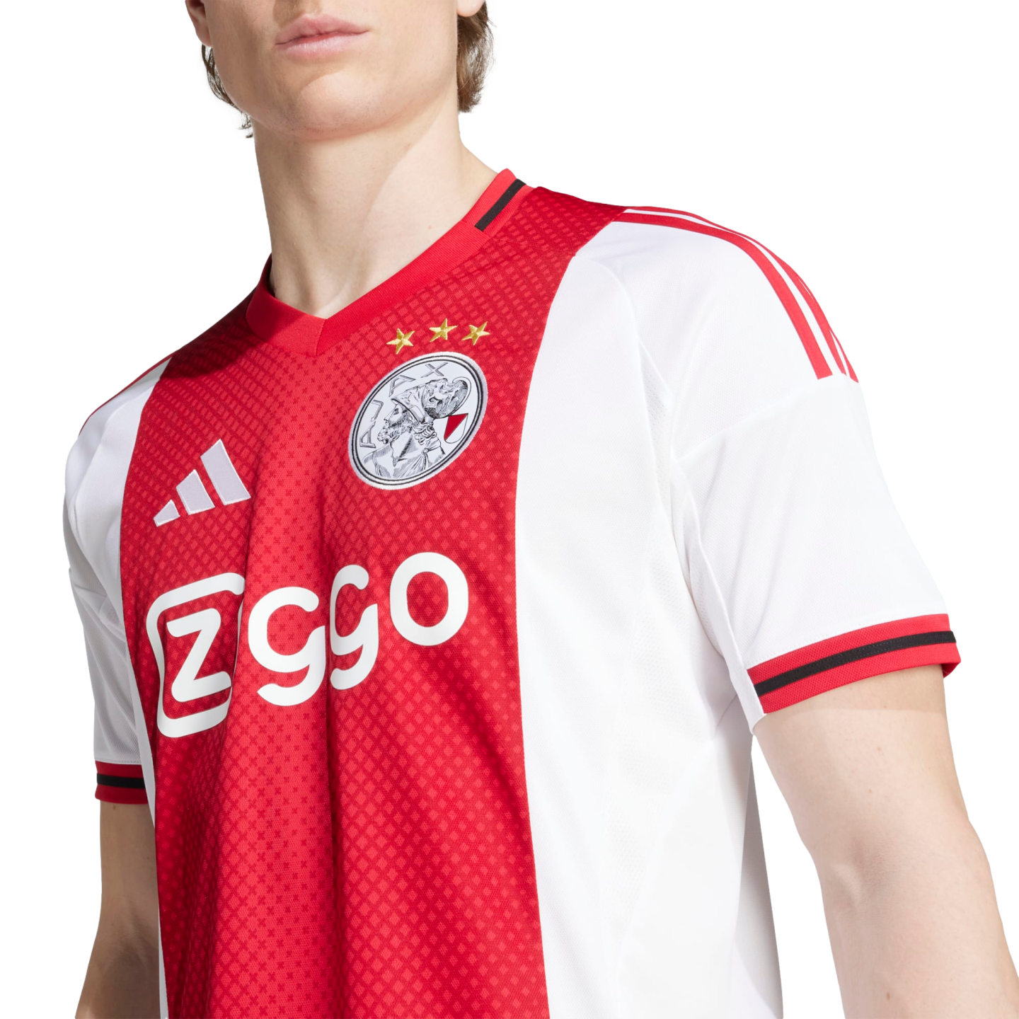 Close-up of a person wearing an official red and white Ajax Amsterdam home jersey with the club crest and Ziggo sponsor logo.