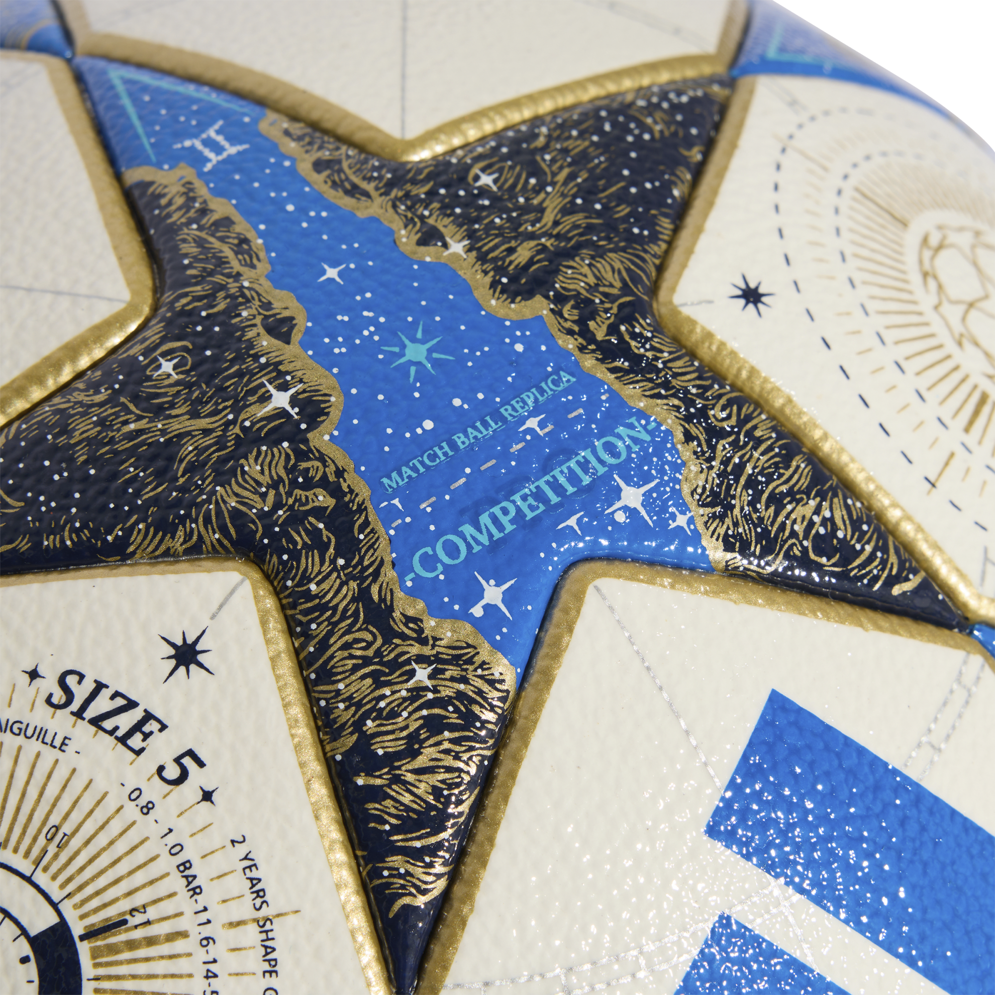 Close-up of a white and blue star-paneled soccer ball with gold accents and cosmic designs. Text includes "MATCH BALL REPLICA COMPETITION" and "SIZE 5".