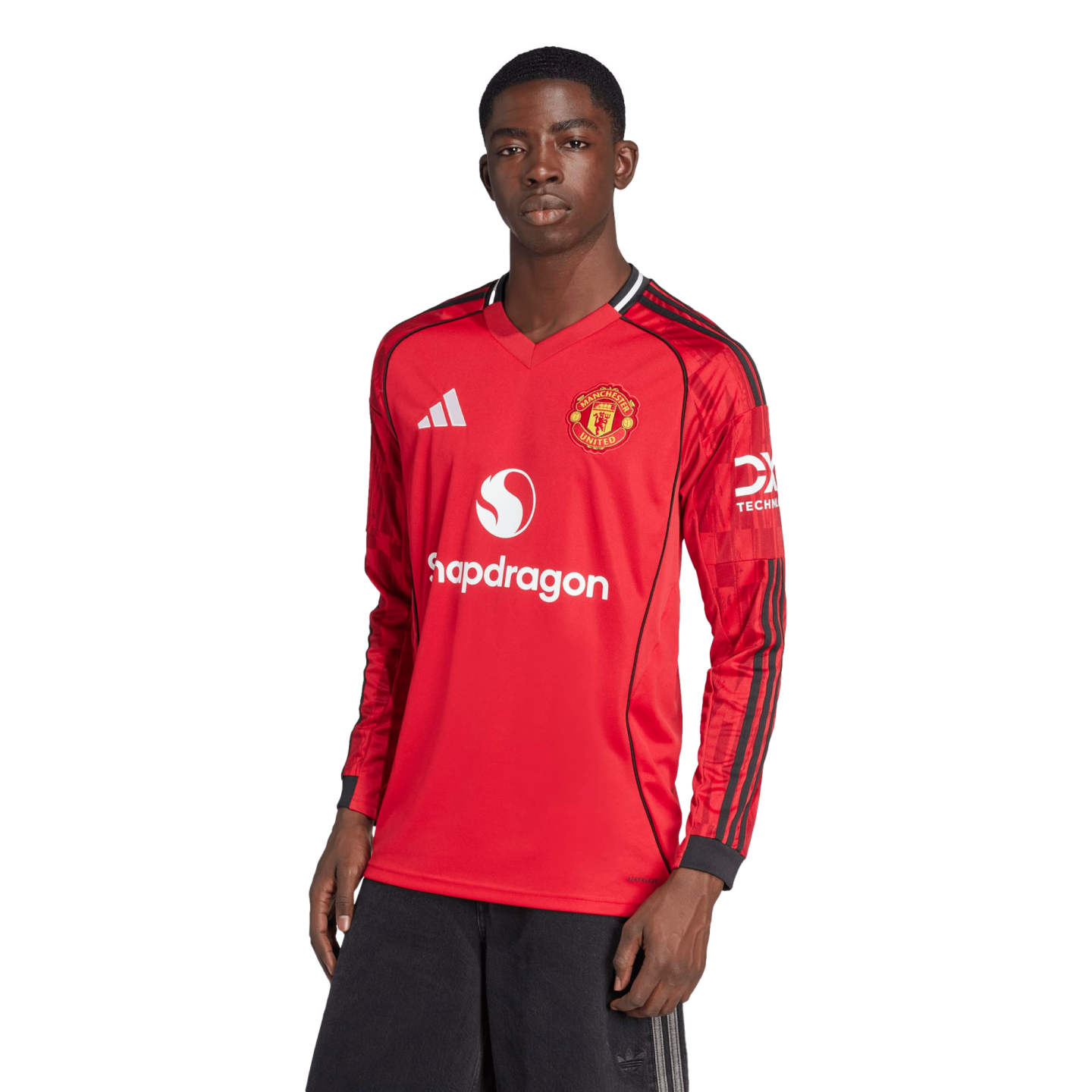 Model wearing a red long-sleeve Manchester United 2024-25 home jersey with white Adidas and Snapdragon logos, posed against a black background.