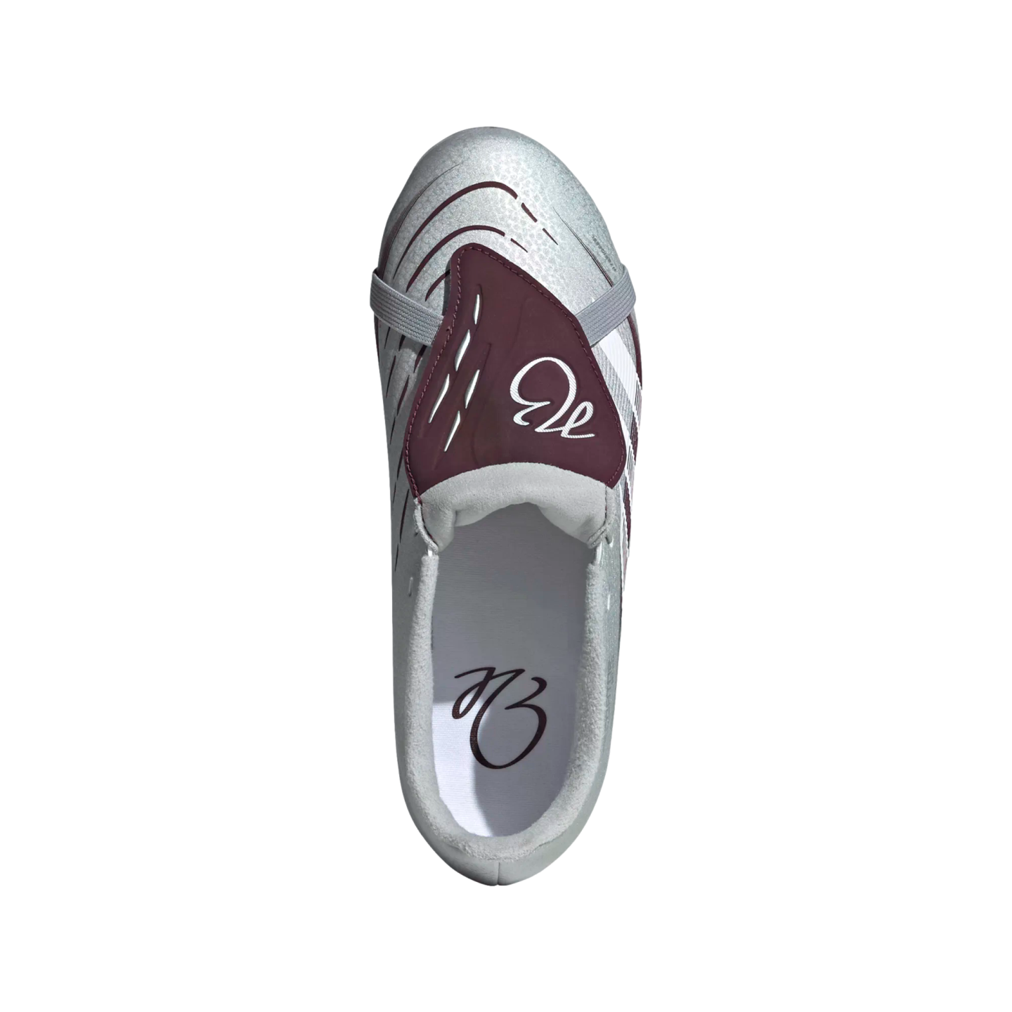 Top-down view of a metallic silver and maroon laceless soccer cleat against a white background.