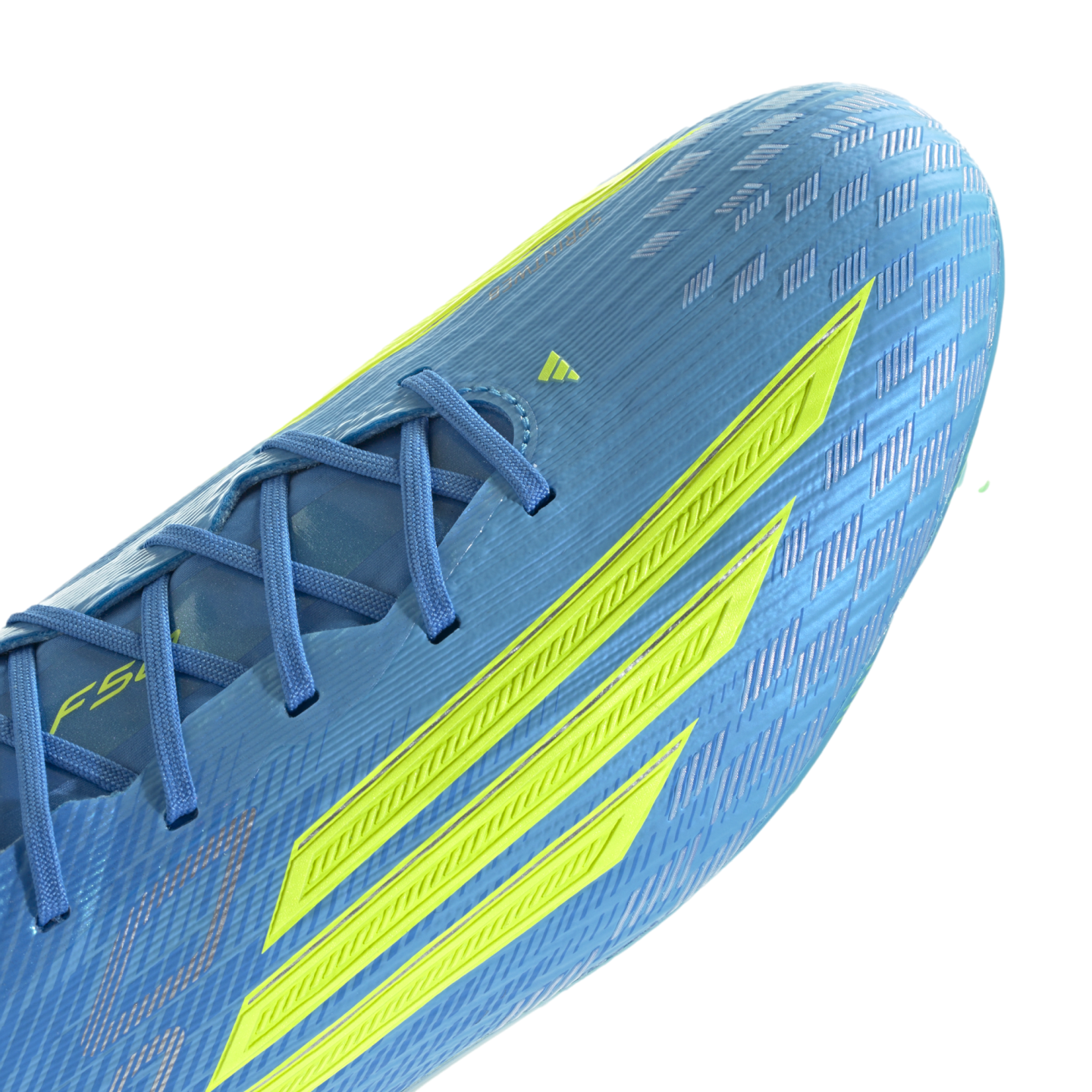 A close-up of a light blue Adidas F50 soccer cleat featuring three bold neon yellow stripes on the side. The shoe has a textured, ribbed upper with blue laces and a shimmering checkered pattern near the toe, shown against a black background.