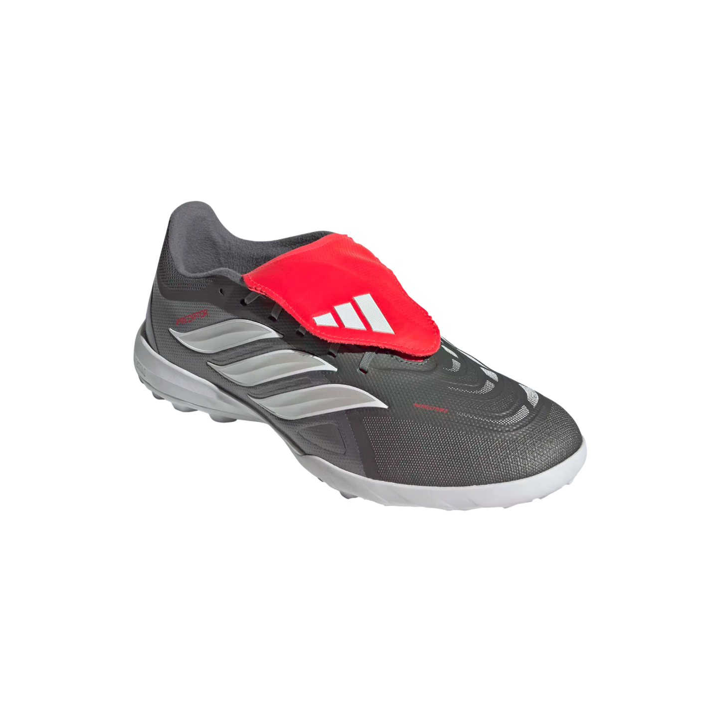 A grey Adidas Predator soccer shoe featuring a large red fold-over tongue with a white logo and signature white stripes on the side.