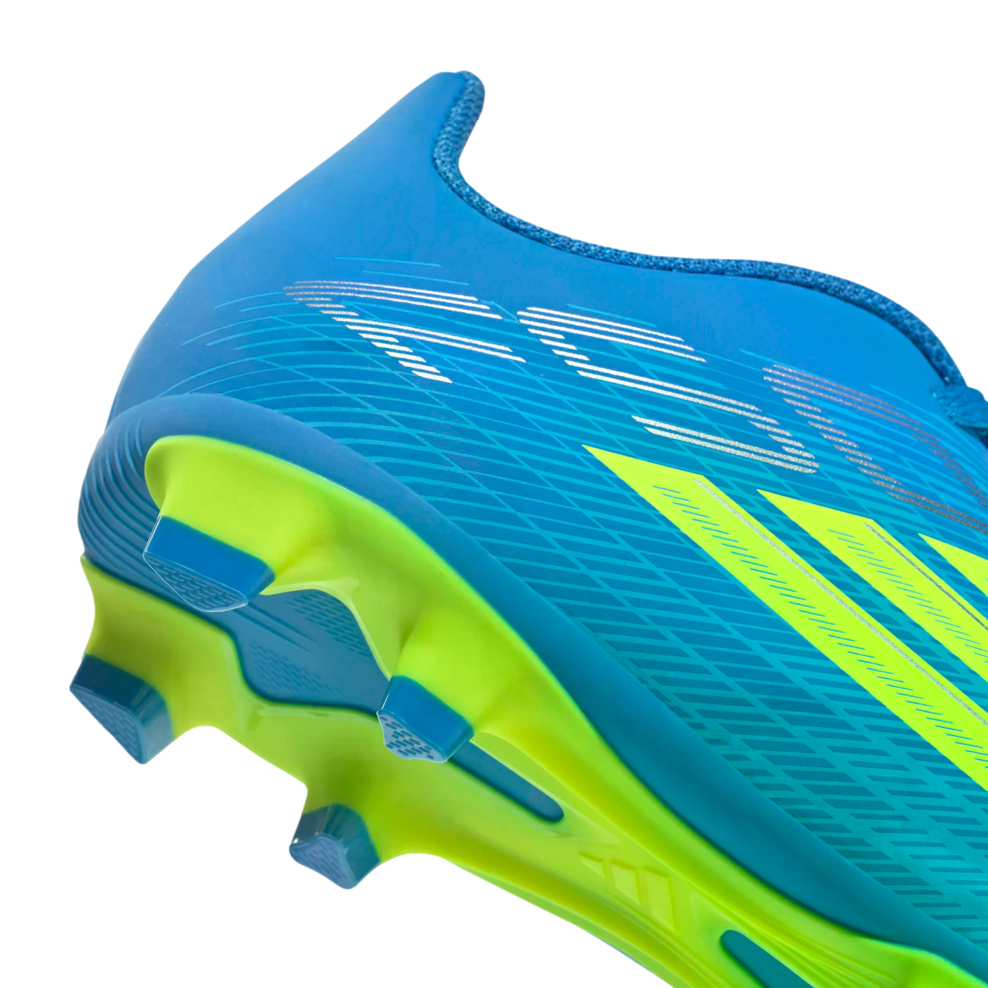 A close-up, side-angle view of the heel and sole of a bright blue soccer cleat against a black background. The shoe features lime green accents, including three diagonal stripes and a vibrant green soleplate with blue triangular studs. Silver graphic line