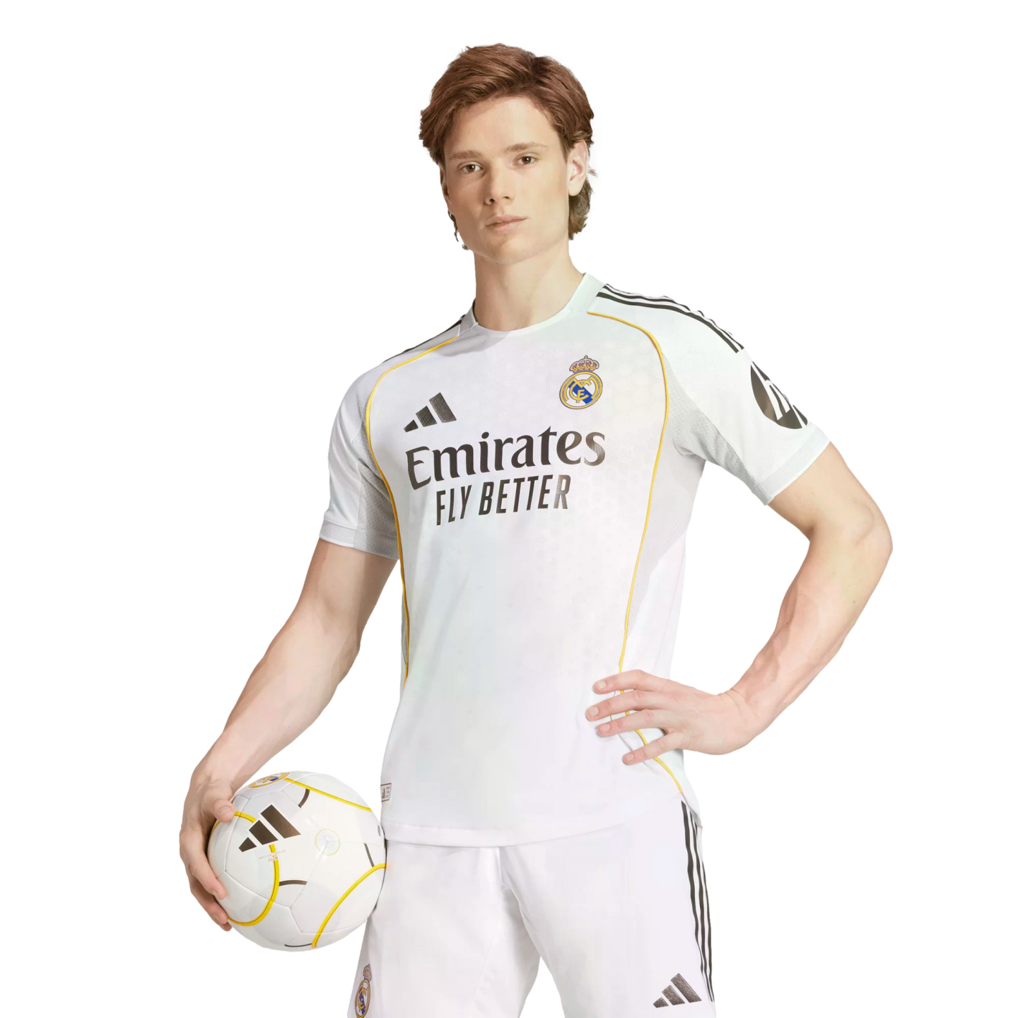 A man in a white Real Madrid kit poses with a soccer ball against a white background, holding the ball in one hand and resting the other on his hip.