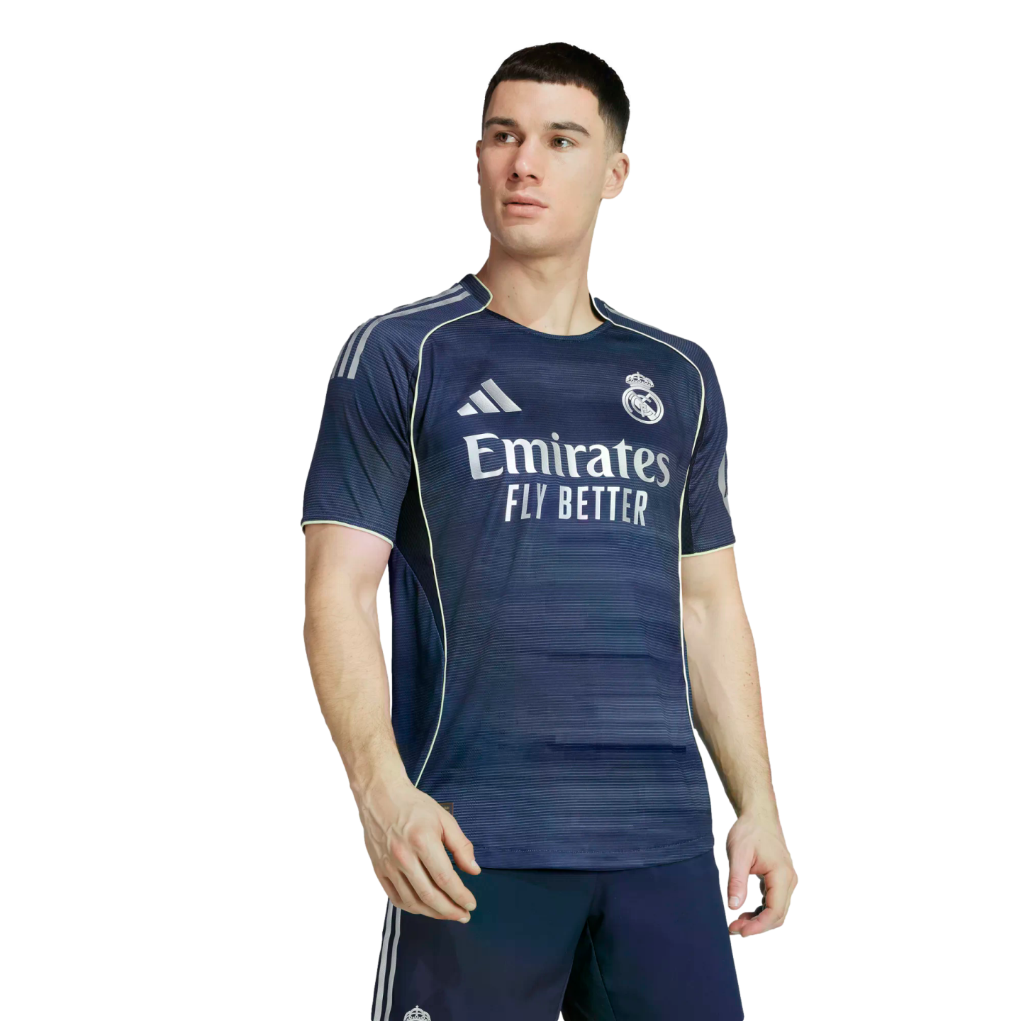 Male model wearing a navy blue Real Madrid soccer jersey with white sponsor text and light green piping against a white background.