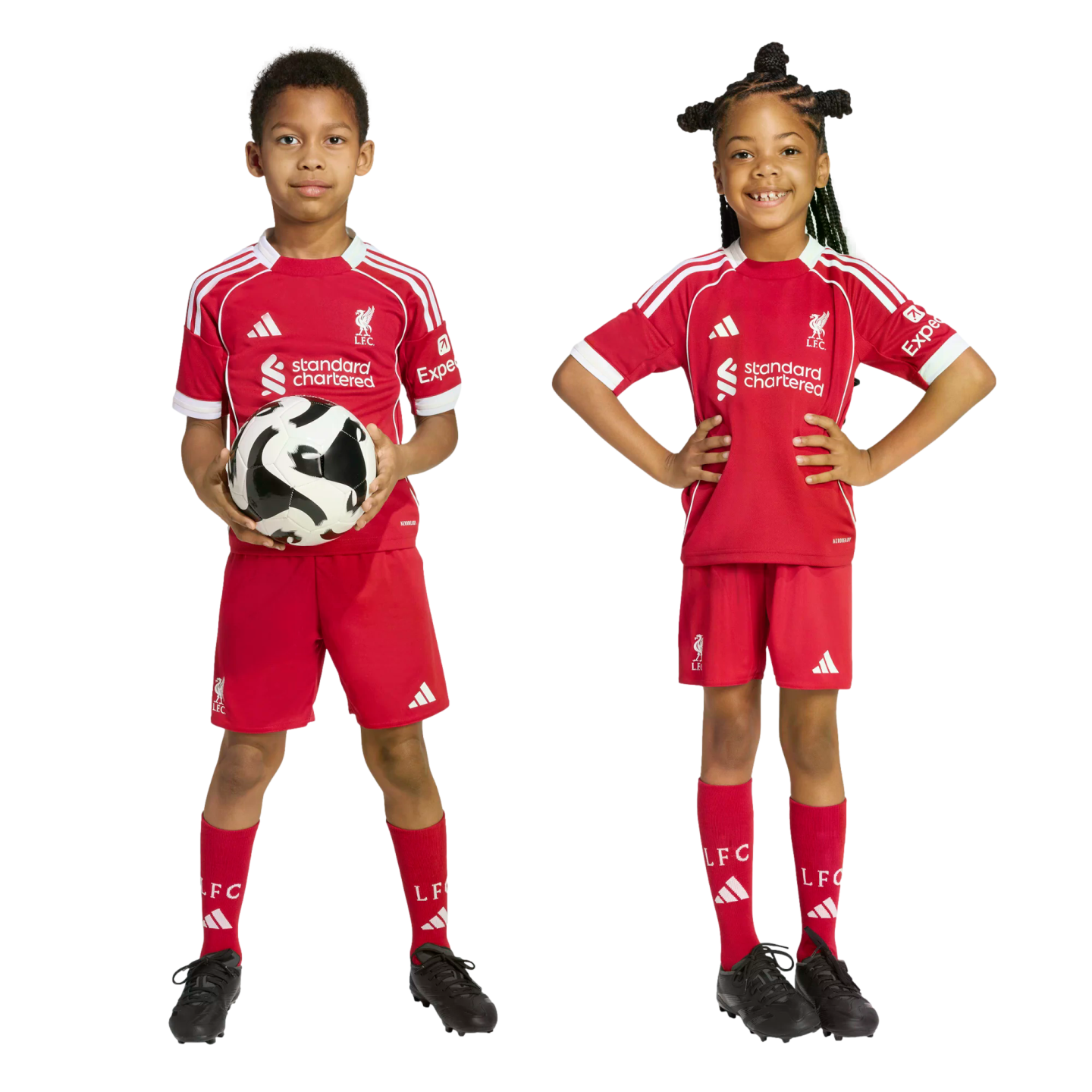 Two children wearing red Liverpool FC football kits. A boy holds a soccer ball while a girl smiles with her hands on her hips.