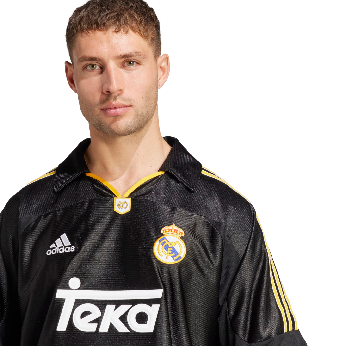 A portrait of a man with light green eyes and short brown hair, wearing a vintage-style black Real Madrid away jersey with yellow accents. The jersey features the adidas logo, the club crest, and the "Teka" sponsor name in white. He is looking directly at