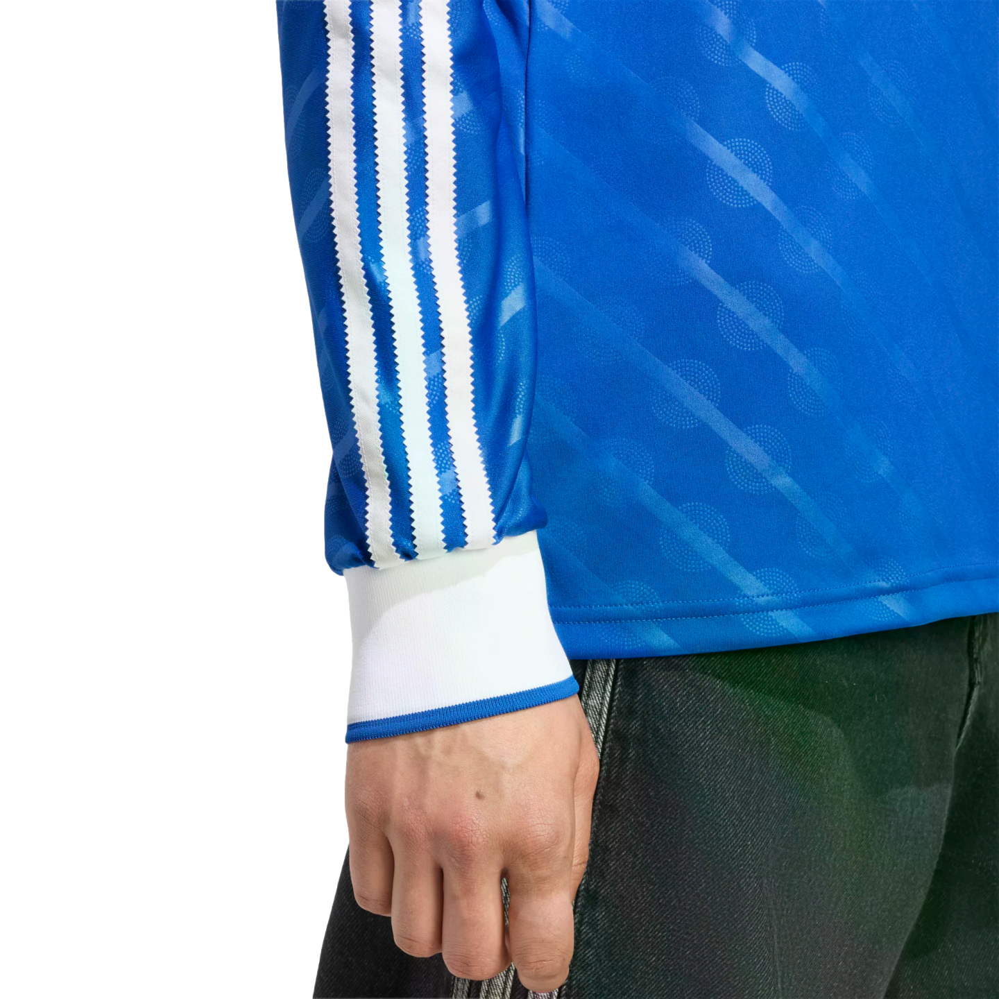 Blue long-sleeve shirt with three white stripes on the sleeve, white cuffs, and a diagonal pattern. Hand and dark pants are visible.