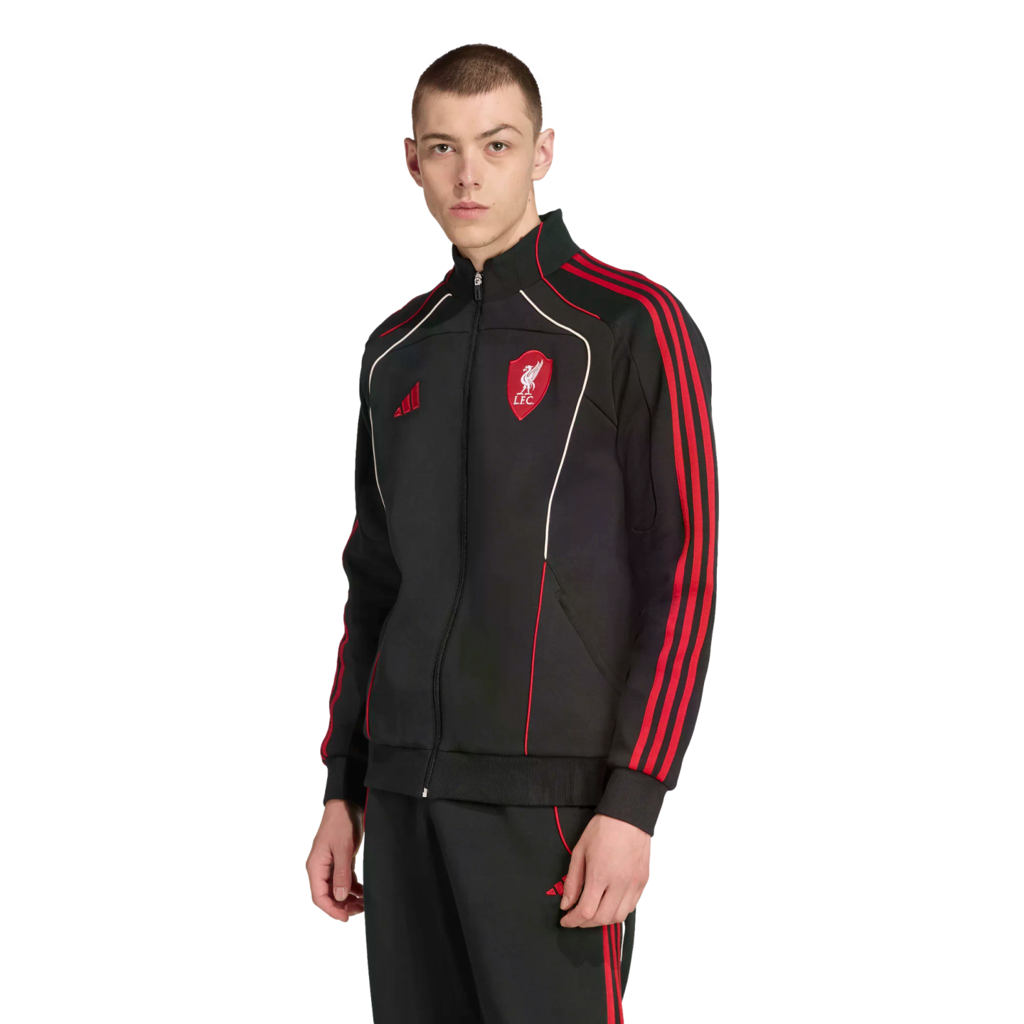 Man wearing a black Adidas Liverpool FC tracksuit with red stripes and white piping against a black background.