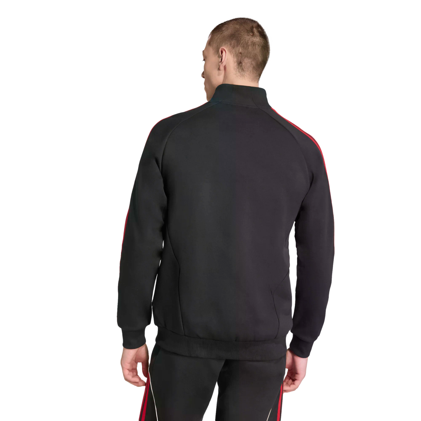 Rear view of a man wearing a black tracksuit with red stripes along the shoulders and pants, standing against a solid black background.