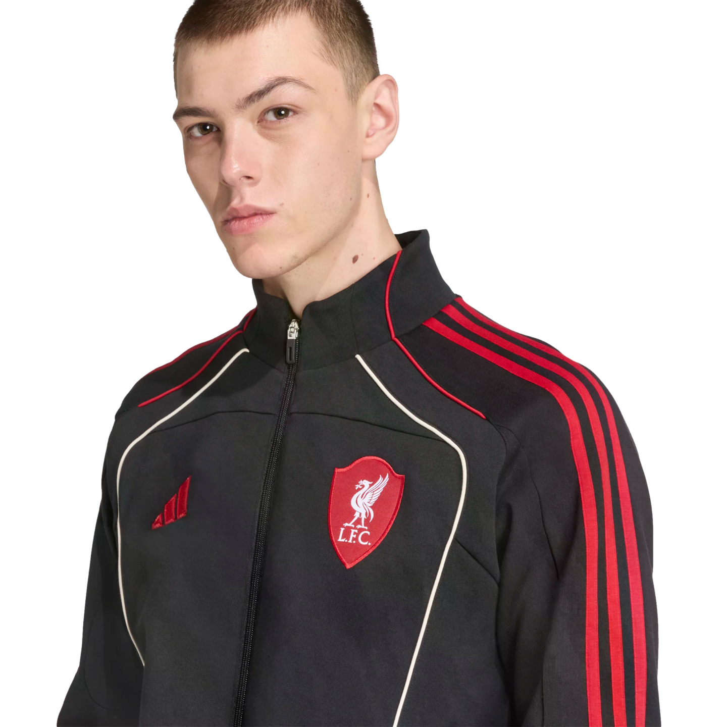 A man wearing a black Adidas Liverpool F.C. track jacket with red stripes and white piping, set against a black background.