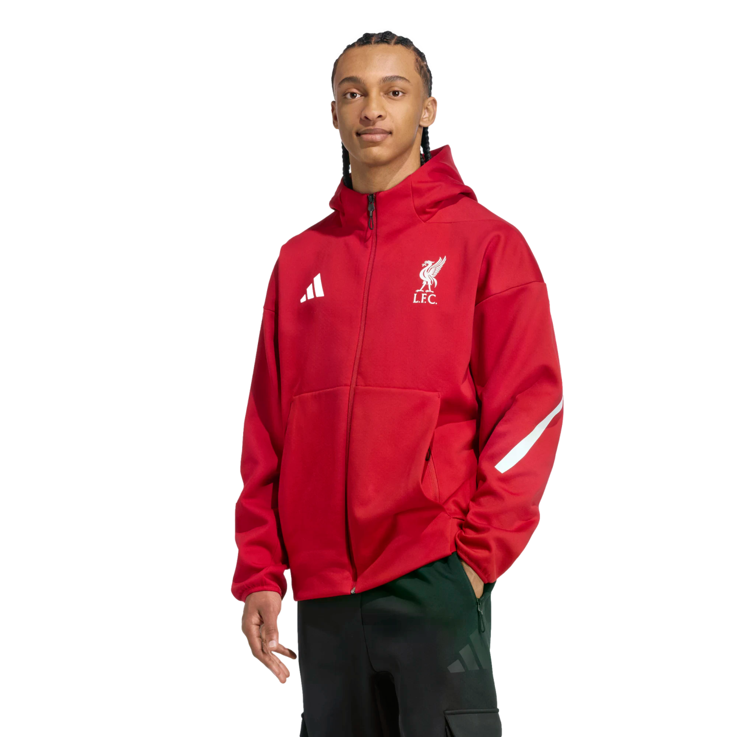 A man wears a red Liverpool FC zip-up hoodie and black athletic pants against a black background.