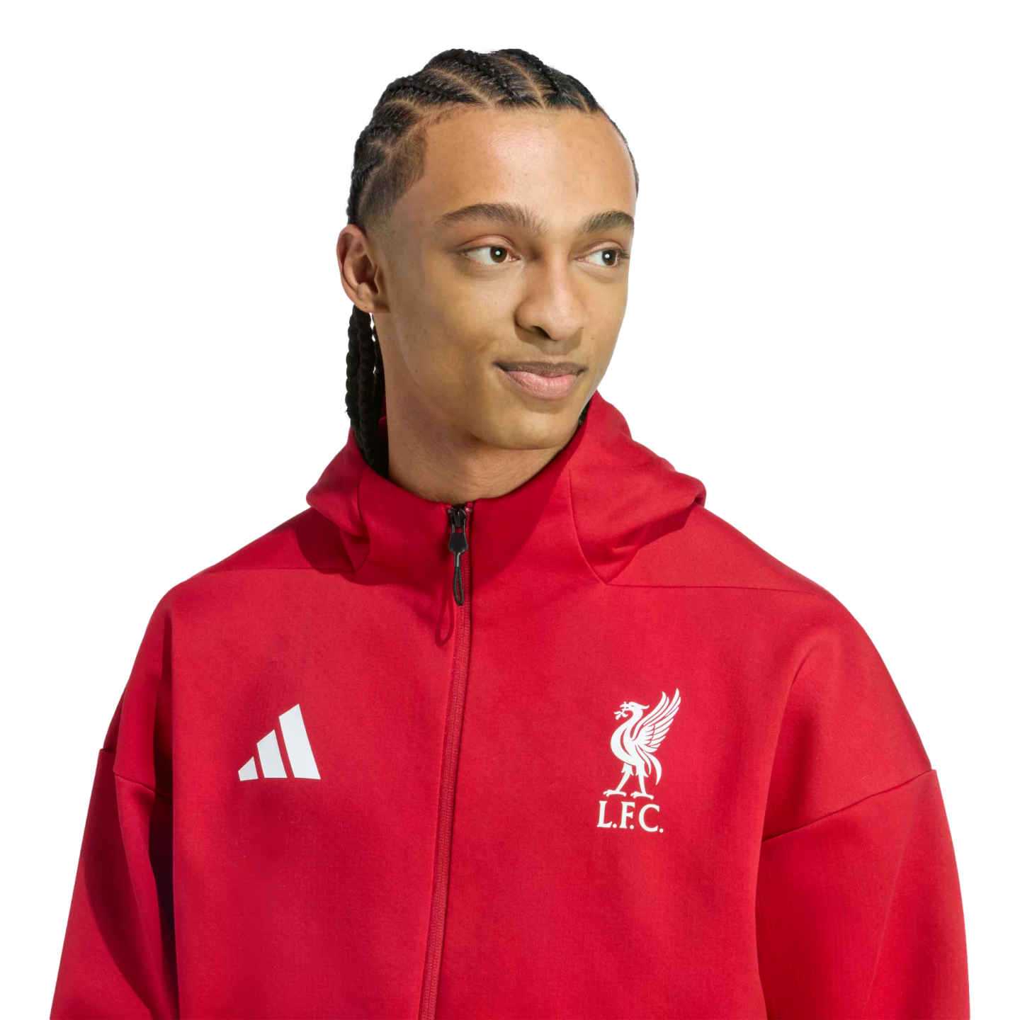 A man with braided hair wearing a red Adidas Liverpool FC hoodie, looking to the side against a black background.