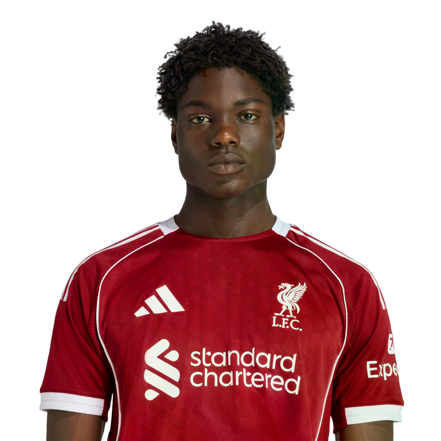 A headshot of a young Black man with curly hair wearing a red Liverpool F.C. jersey against a solid black background.