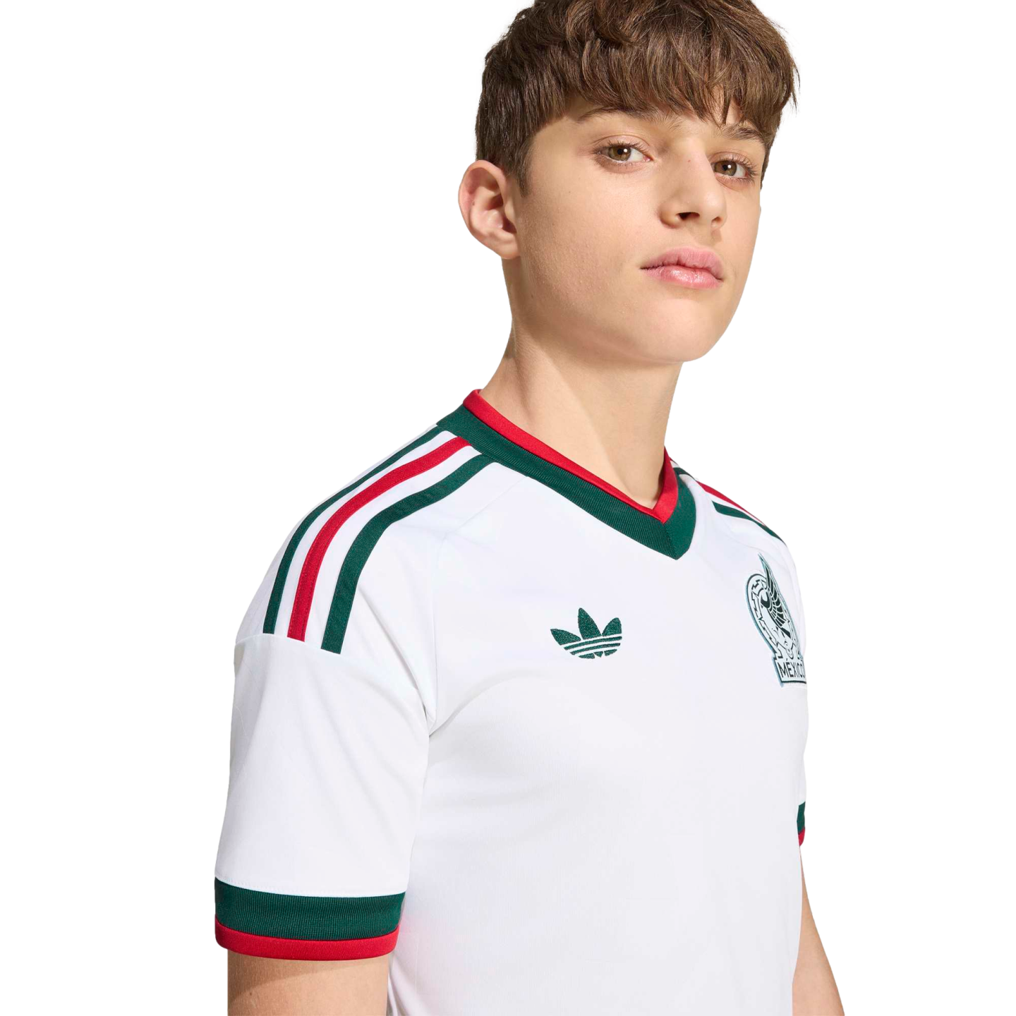 A young man wearing a white Mexico football jersey with green and red trim, an Adidas logo, and team crest, set against a black background.