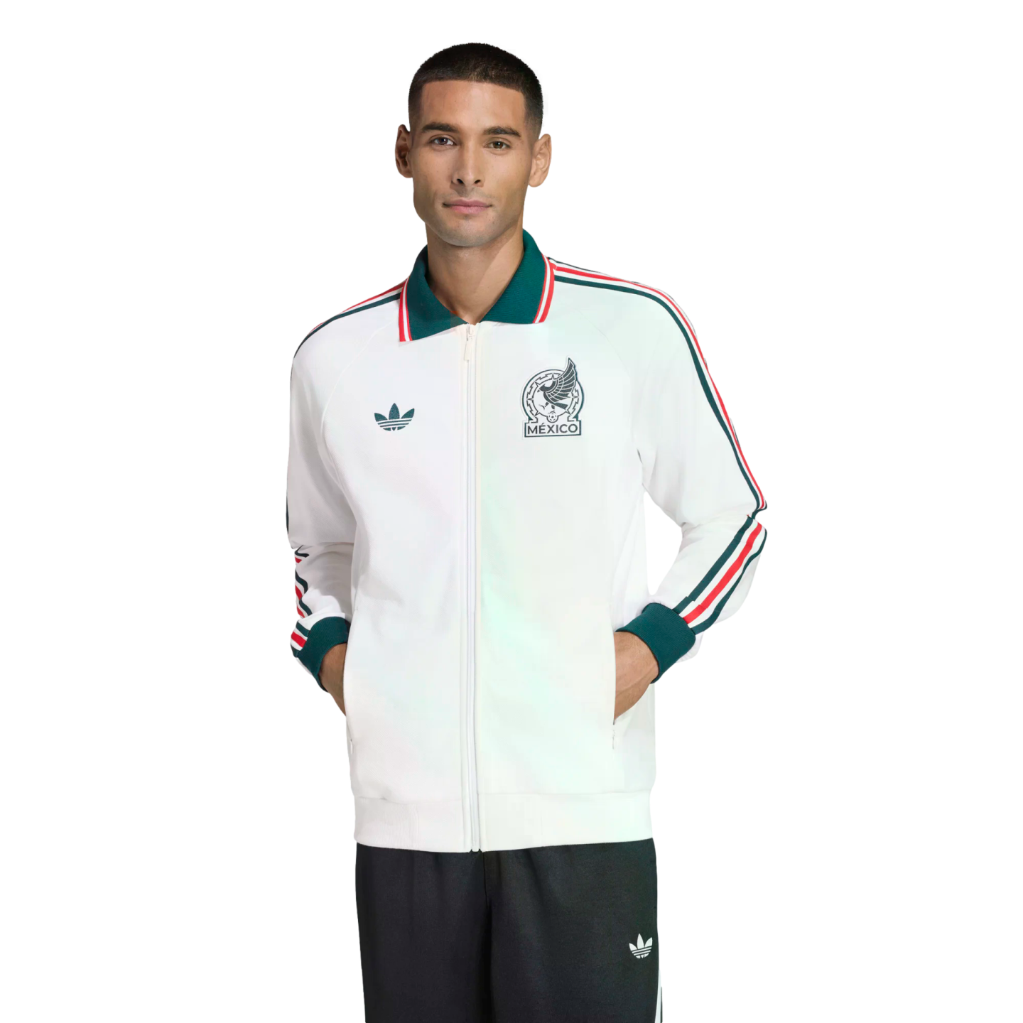 Man modeling a white Adidas Mexico track jacket with green and red accents and a Mexico crest, paired with dark pants against a black background.