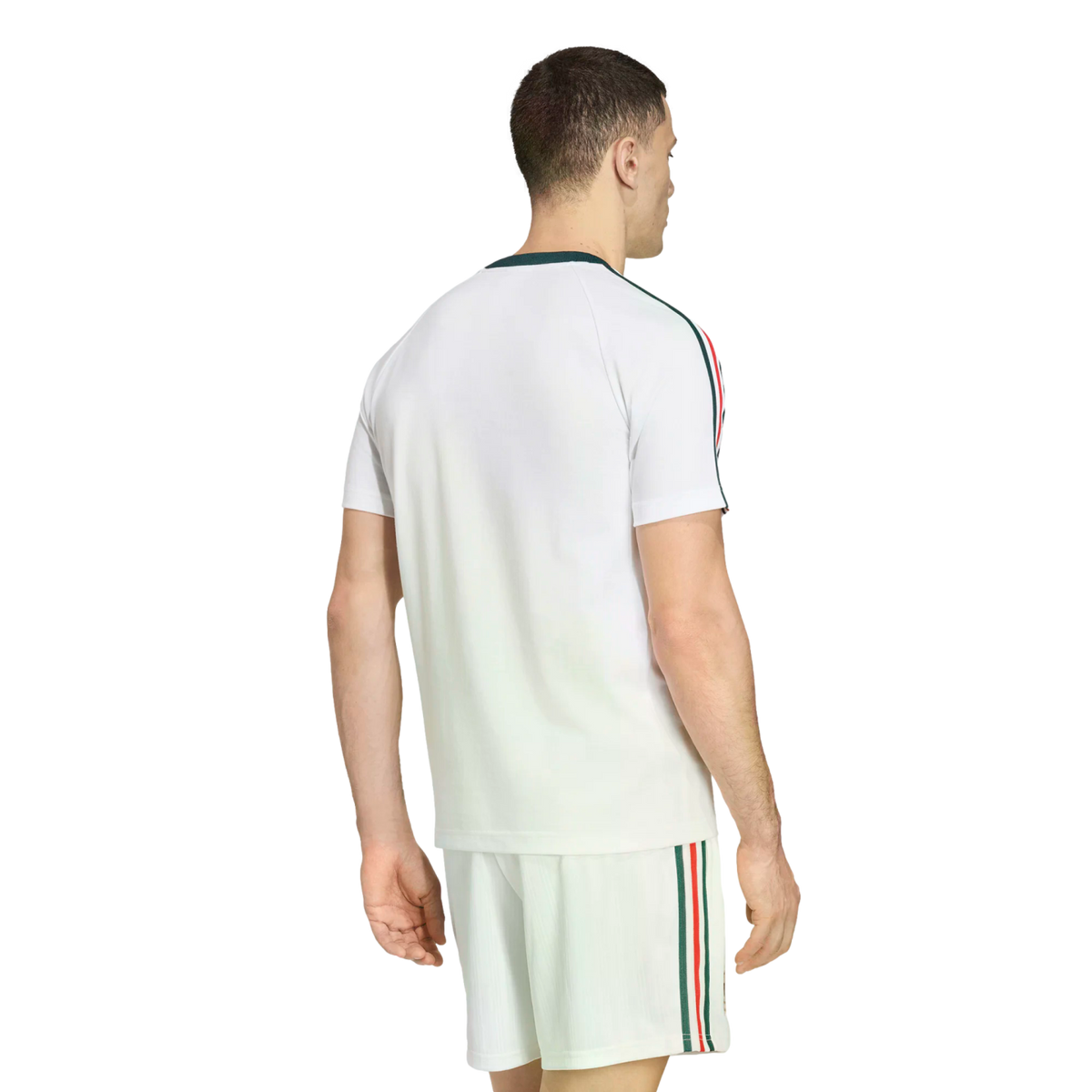 Rear view of a man wearing a white athletic t-shirt and matching shorts set, featuring green, red, and white stripes down the sleeves and sides, set against a black background.