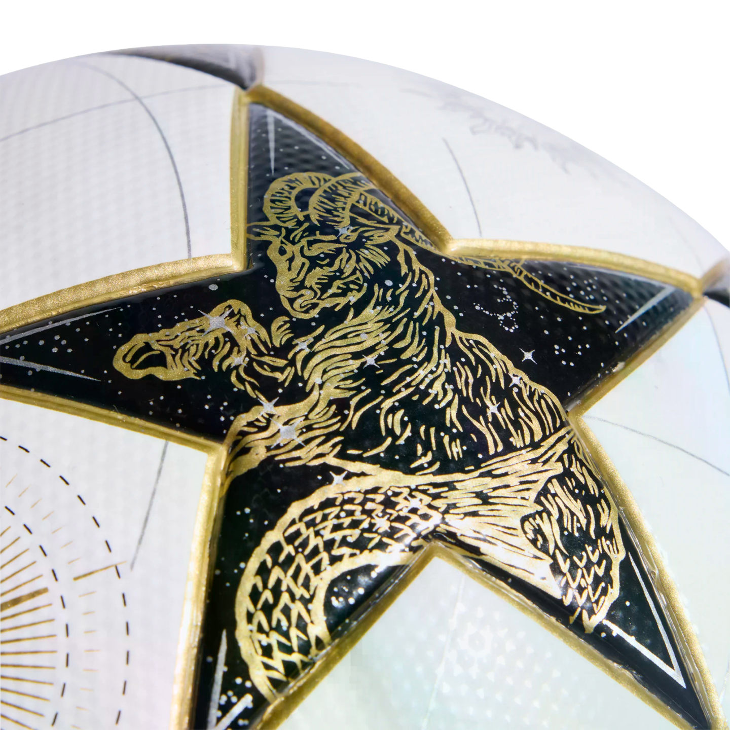 Close-up of a white soccer ball's star-shaped panel featuring a gold-etched Capricorn sea-goat against a black, starry background.