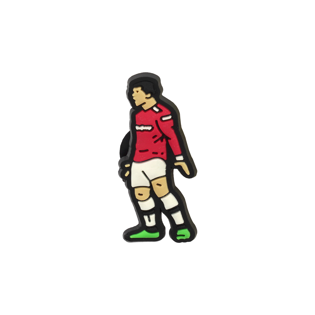 A Soccer Croc Charm depicting a stylized cartoon soccer player wearing a red long-sleeved jersey, white shorts, and green-soled shoes.