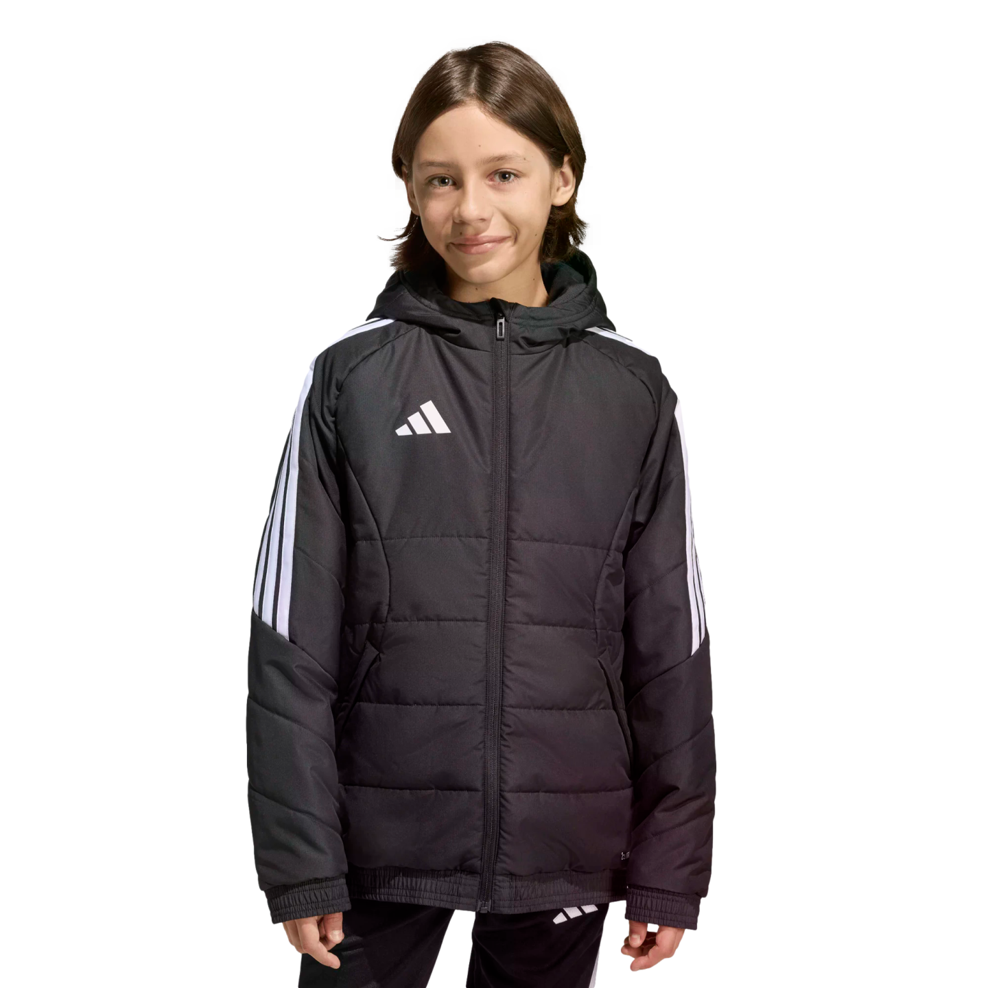 A young person wearing a black Adidas puffer jacket with white stripes on the sleeves and a logo on the chest, standing against a solid black background.