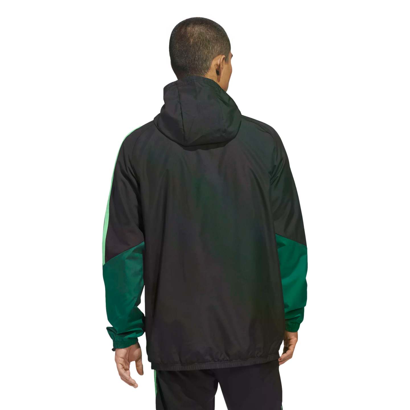 A man seen from behind wearing a black hooded jacket with green paneling on the sleeves, set against a black background.