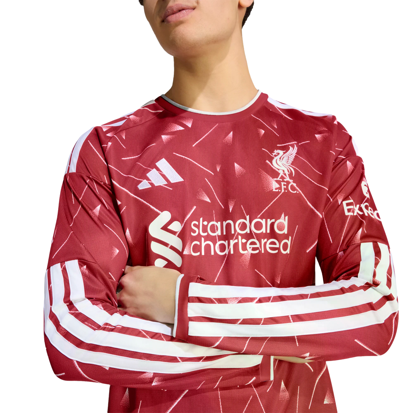 A person wearing a red Liverpool FC long-sleeve Adidas jersey with white patterns, arms crossed against a white background.