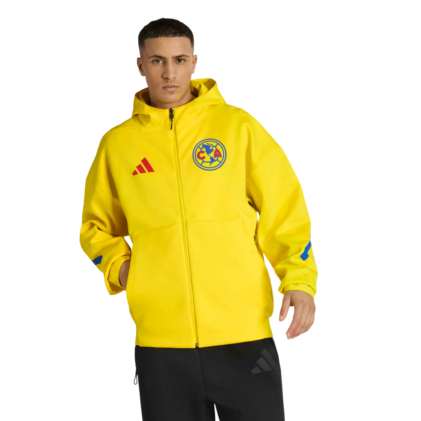 A man models a bright yellow Club América Adidas zip-up hoodie with the team crest and black pants against a solid black background.