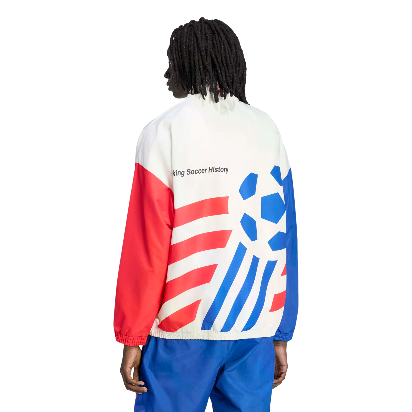Back view of a person with dreadlocks wearing a white, red, and blue track jacket and blue pants against a black background. The jacket features bold red diagonal stripes on one side, a blue stylized soccer ball graphic on the other, and the text "king So