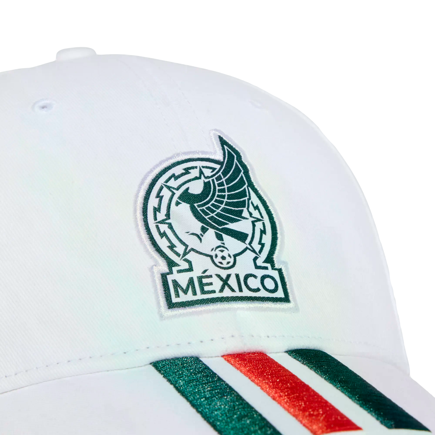 Close-up of a white cap featuring the embroidered Mexico national football team logo and green and red stripes on the brim, set against a black background.