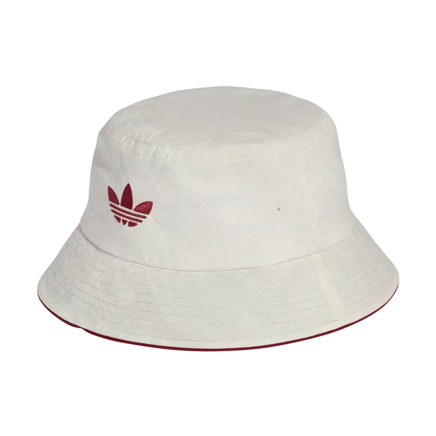 Off-white Adidas bucket hat with a burgundy trefoil logo and trim. The fabric features a subtle tone-on-tone paisley pattern.